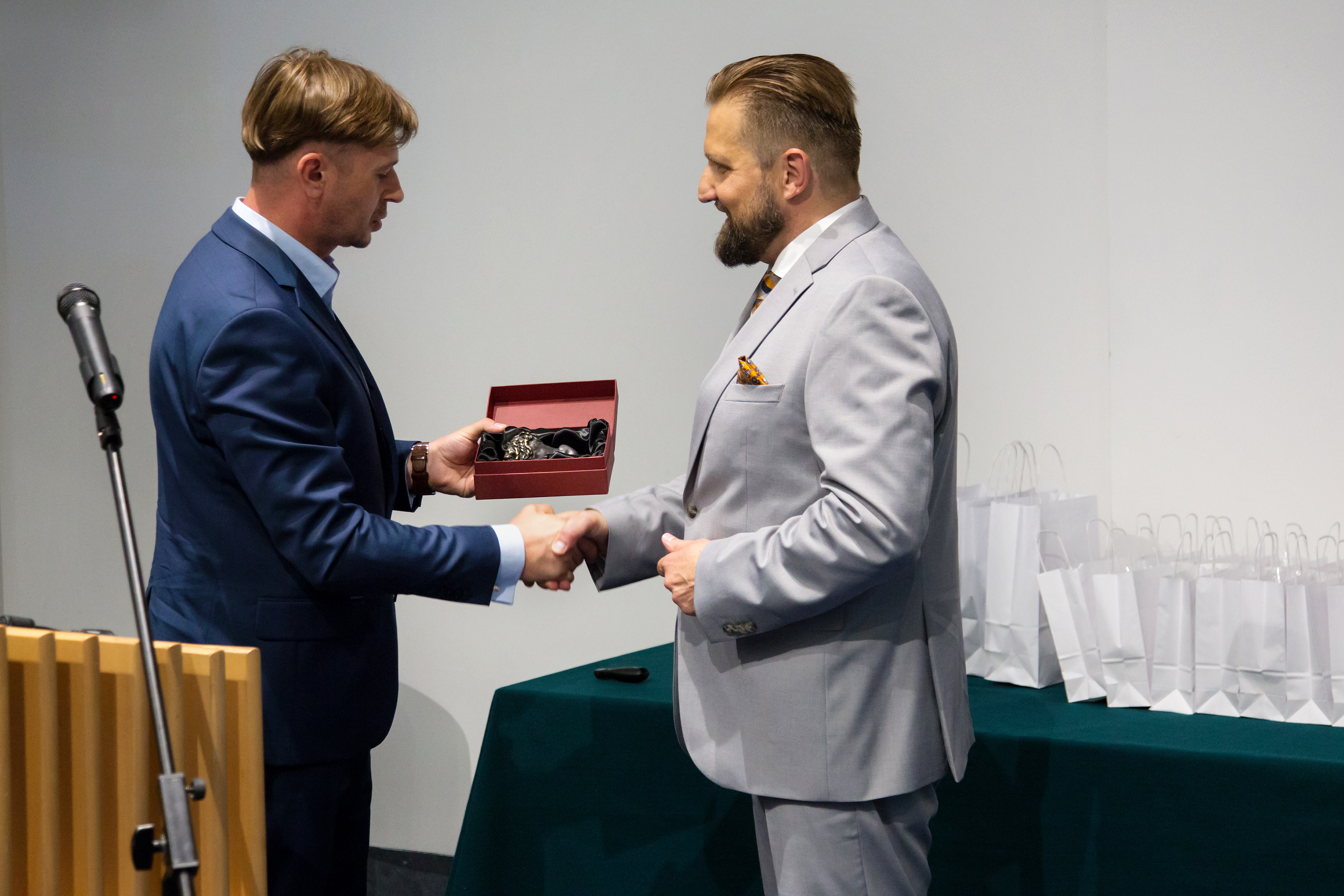 Krystian Tomala wręcza Adamowi Sarkowiczowi statuetkę lwa