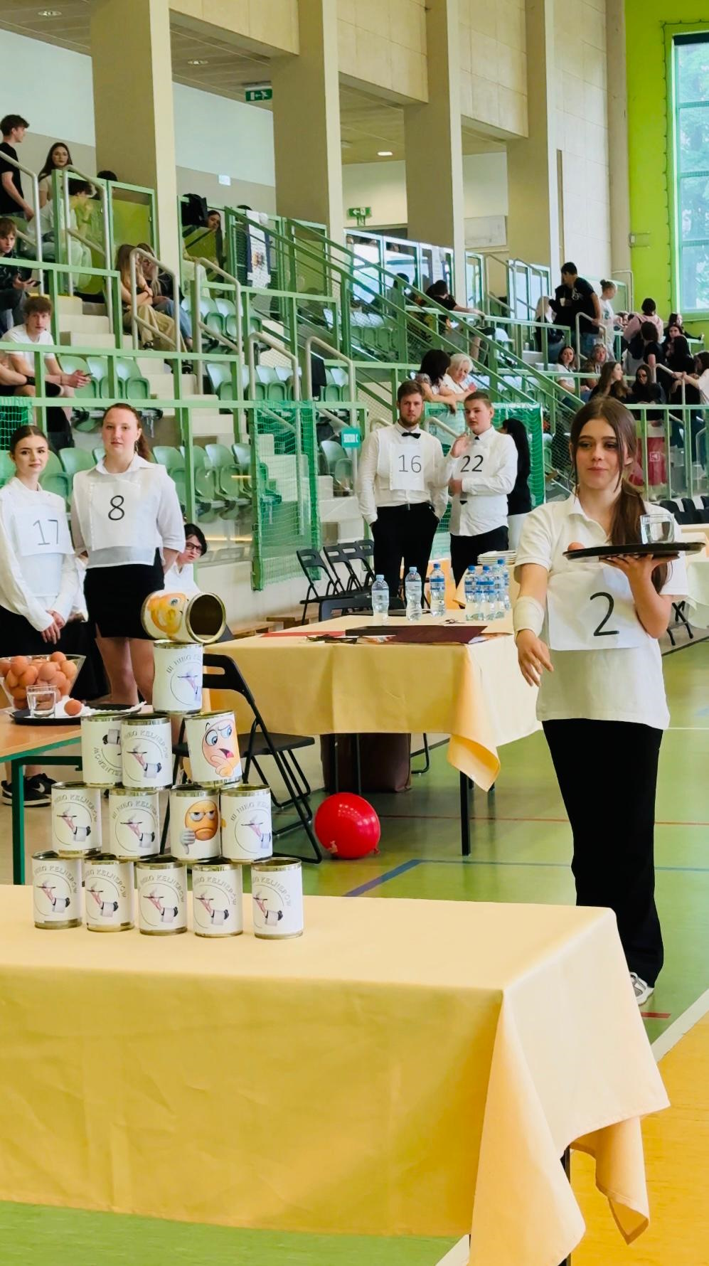 Fot. K. Róg/ UM w Gliwicach Zawodniczka rzucająca zośką do puszek i trzymająca tacę z jajkiem i szklanką wody