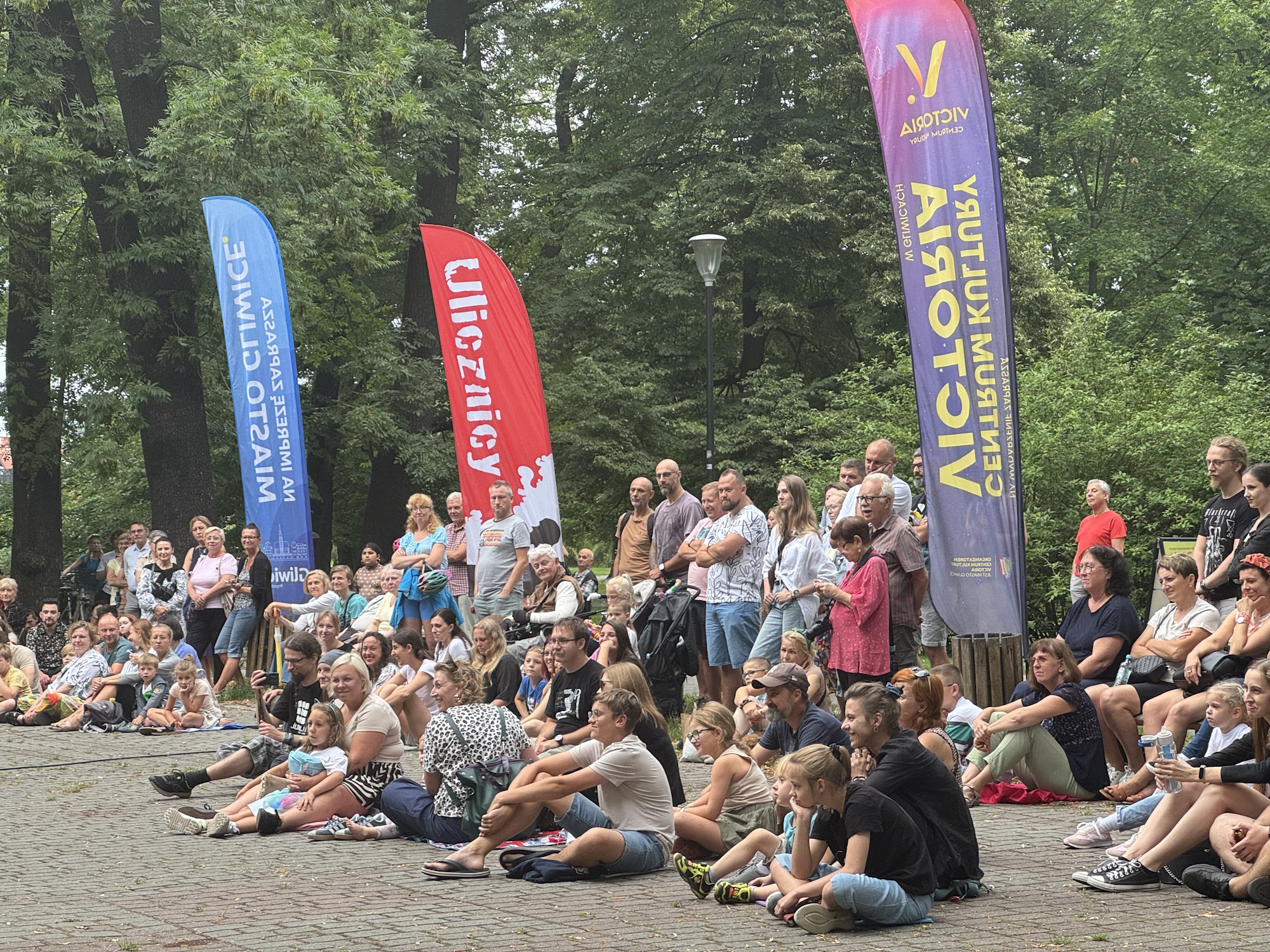 Fot. UM w Gliwicach Ludzie siedzą na ziemi w parku