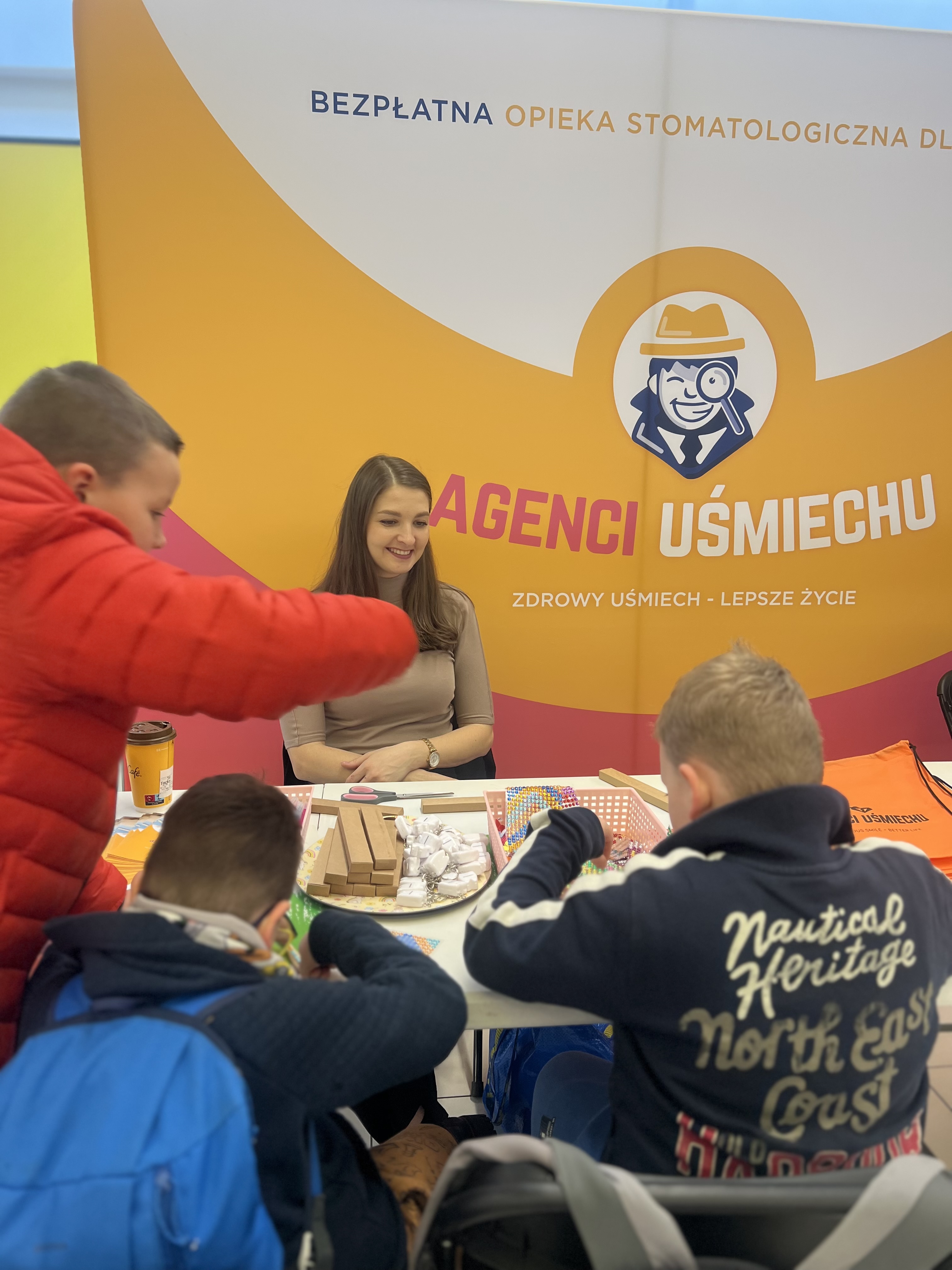 Fot. materiały organizatora kobieta siedzi przy banerze