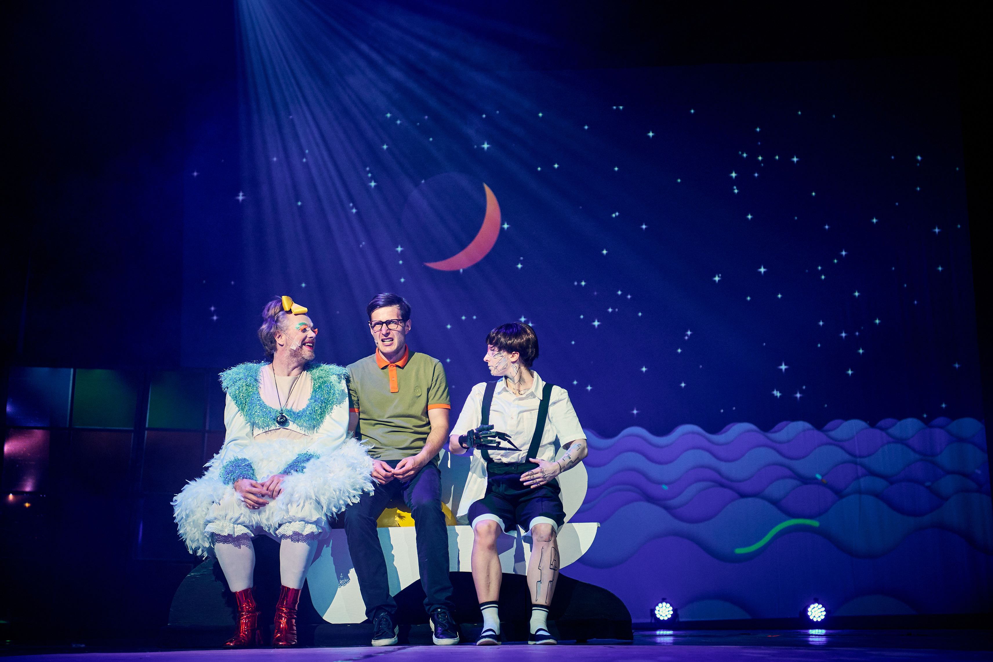 Fot. M. Buksa/UM w Gliwicach Aktorzy w p[rzebraniach na scenie, w tle grafika nocnego nieba