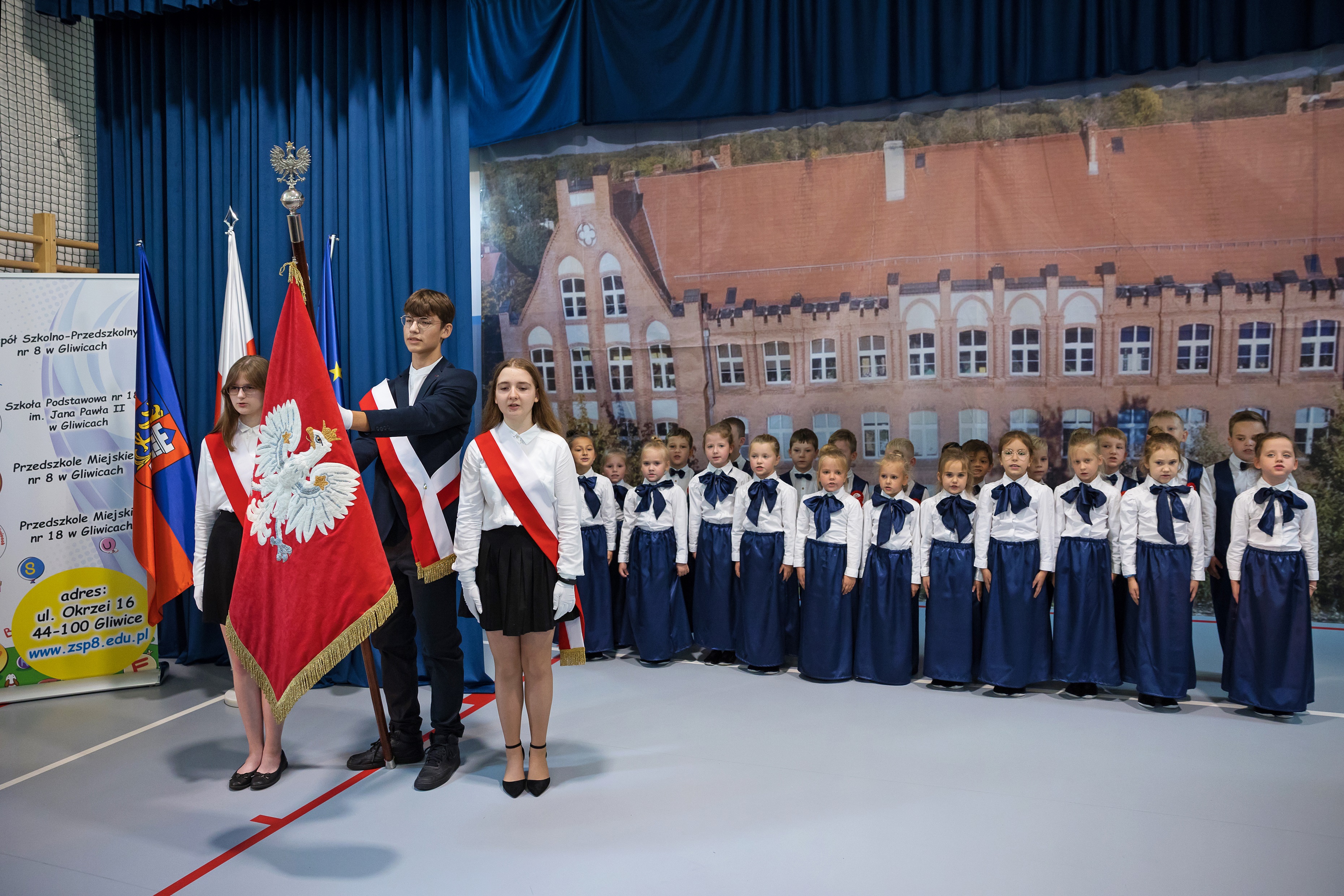 Fot. D. Nita-Garbiec/ UM w Gliwicach Ubrani na galowo uczniowie, stojący na baczność i trzymający sztandar szkoły