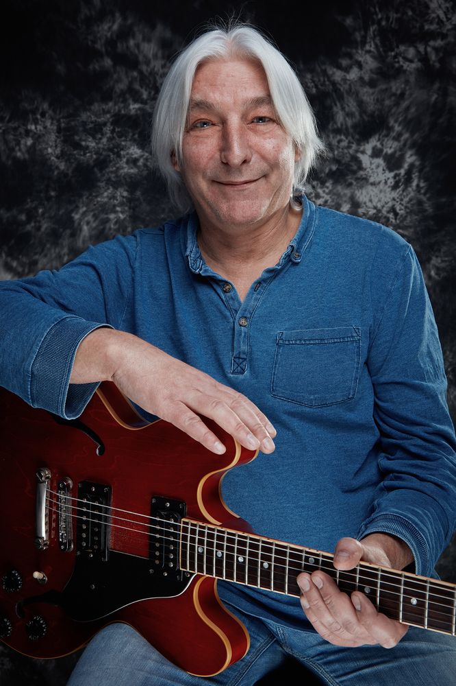 mężczyzna z gitarą w niebieskiej koszuli