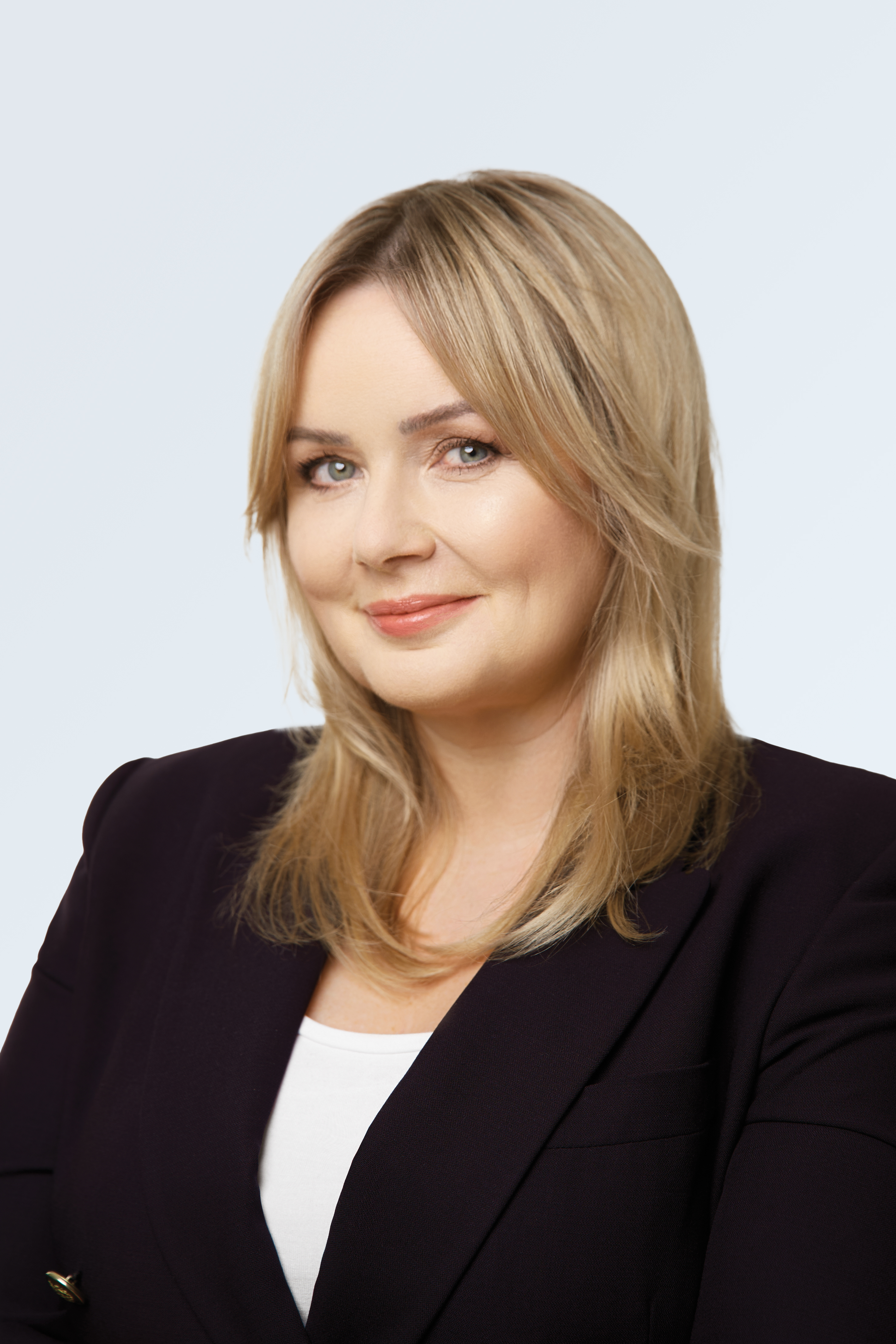 kobieta w długich blond włosach ubrana w czarną marynarkę