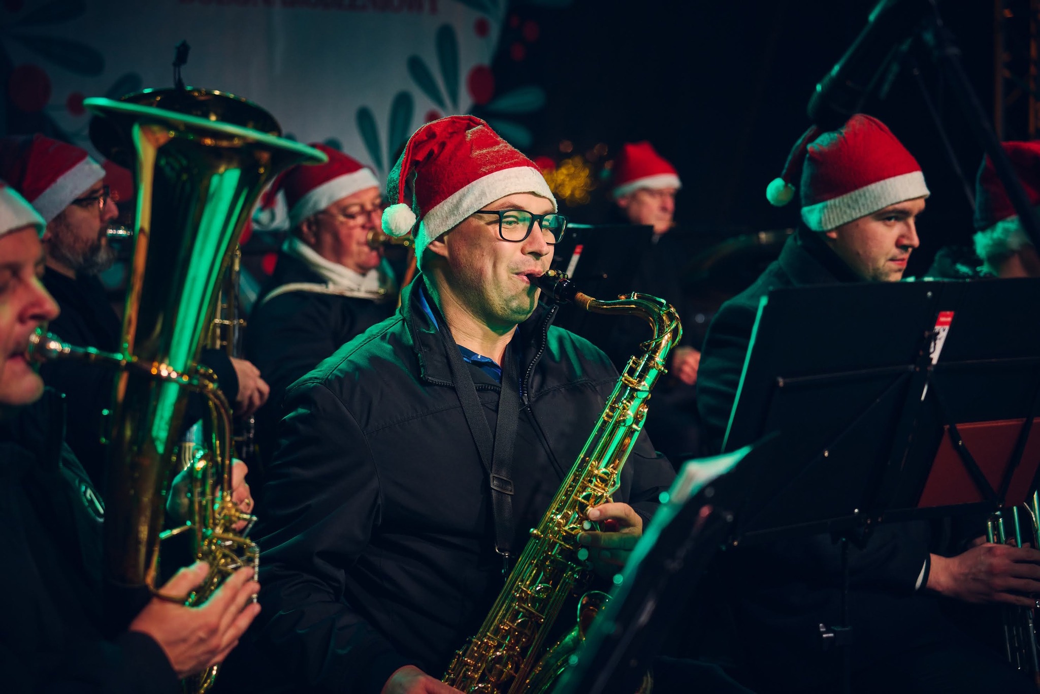 Mężczyźni w czapkach mikołajowych grają na instrumentach
