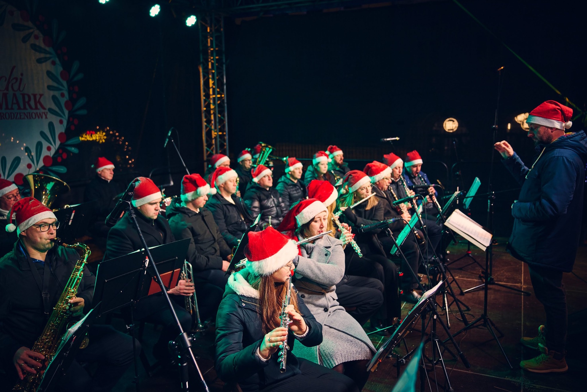 Orkiestra w czapkach mikołaja gra na scenie