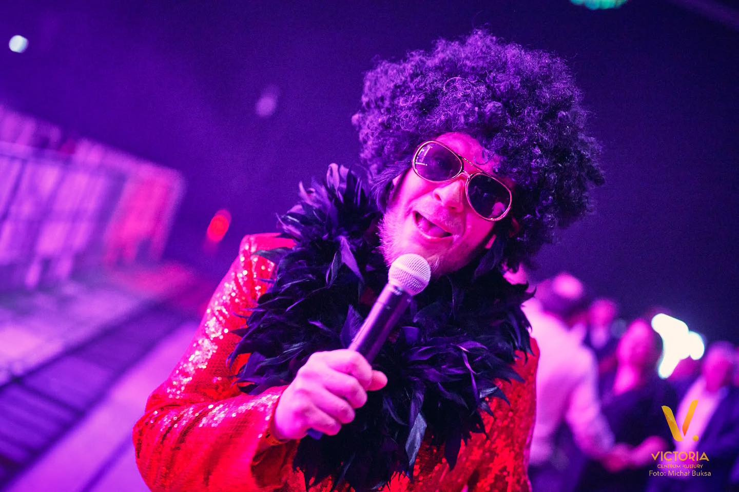 Mężczyzna w peruce i z mikrofonem