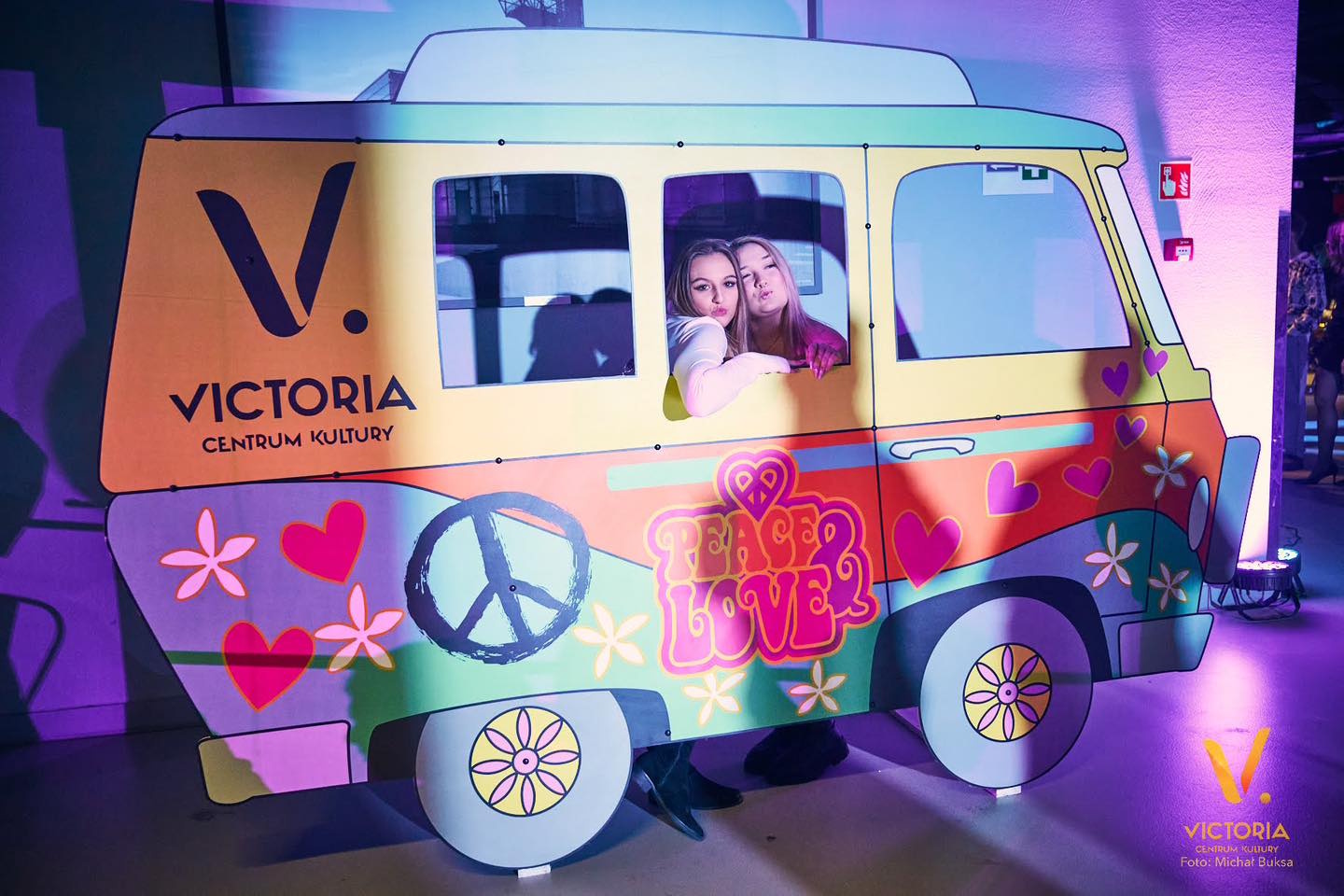 Dziewczyny pozują do zdjęcia z kolorowym autobusem