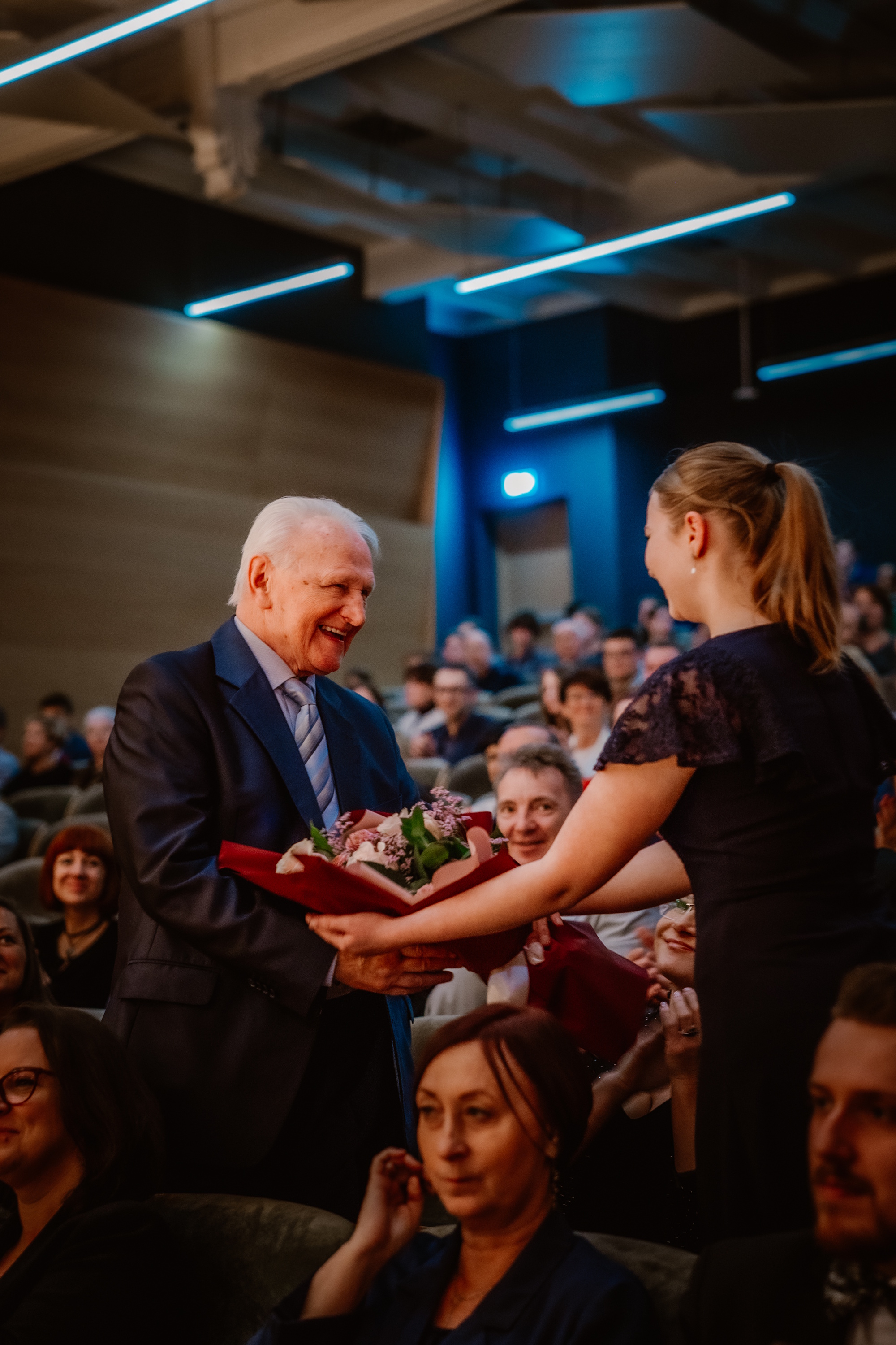 Dziewczyna wręcza kwiaty mężczyźnie