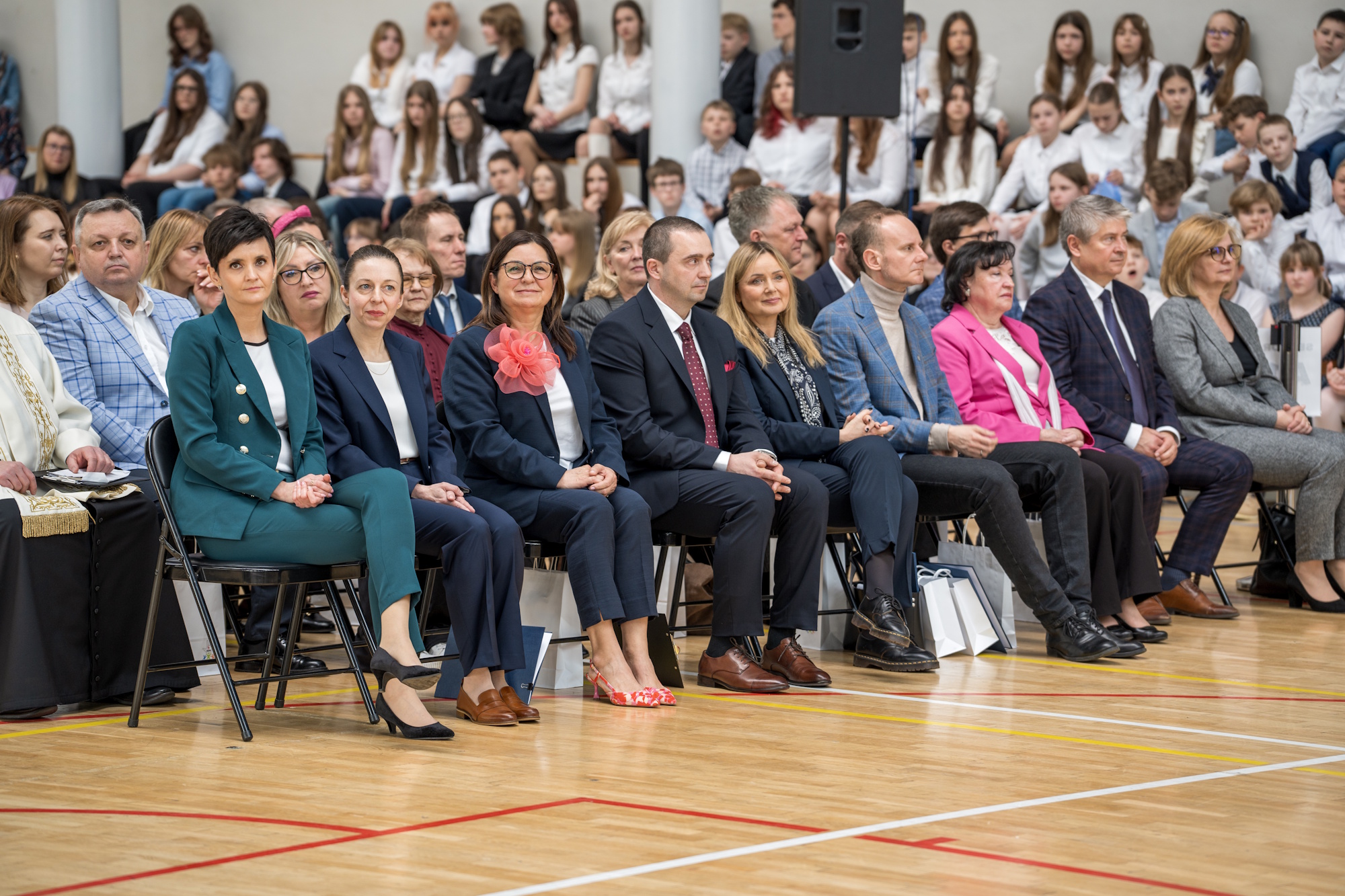 ludzie siedzą w sali gimnastycznej