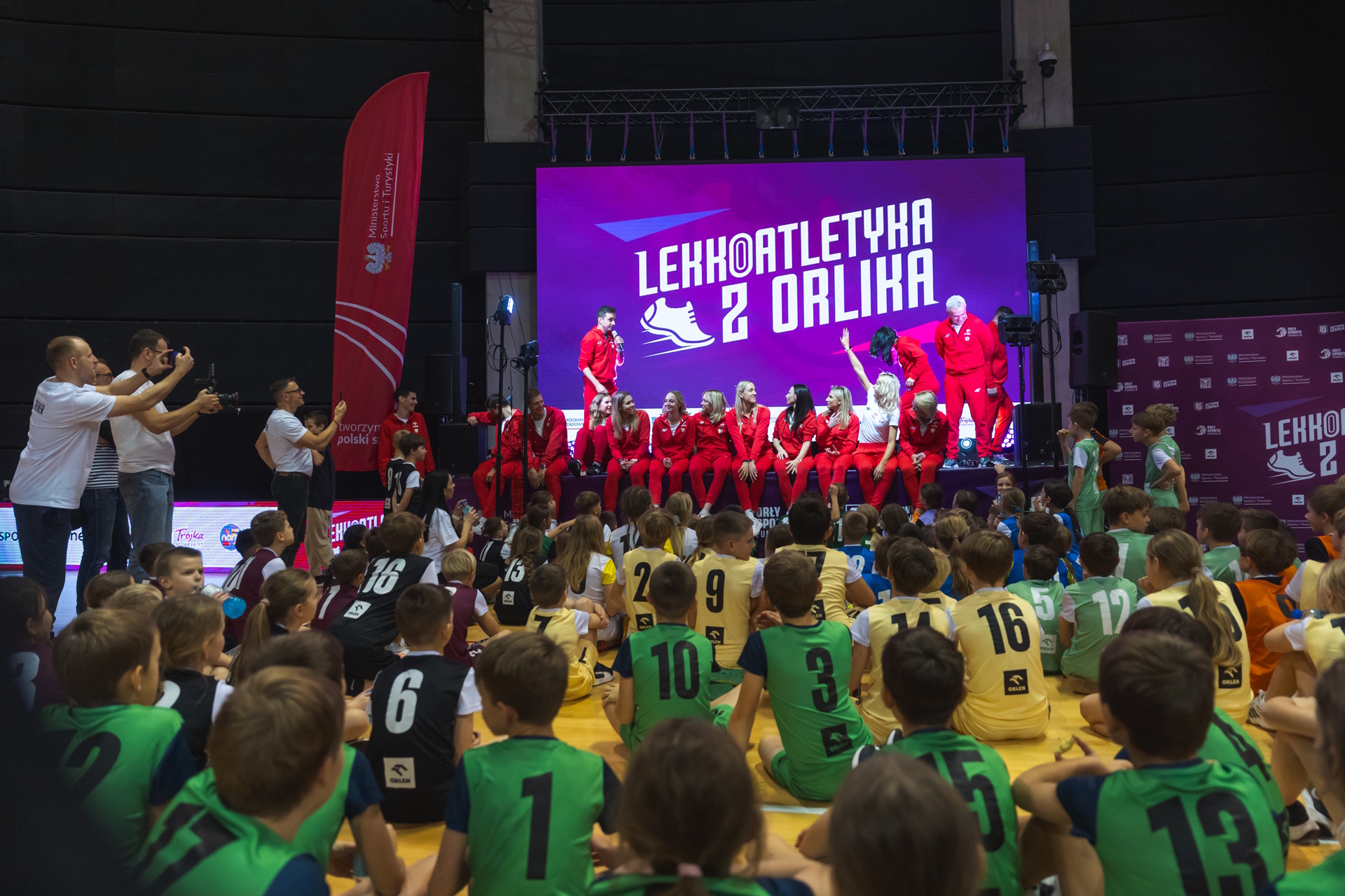 Dzieci słuchające prowadzących na scenie