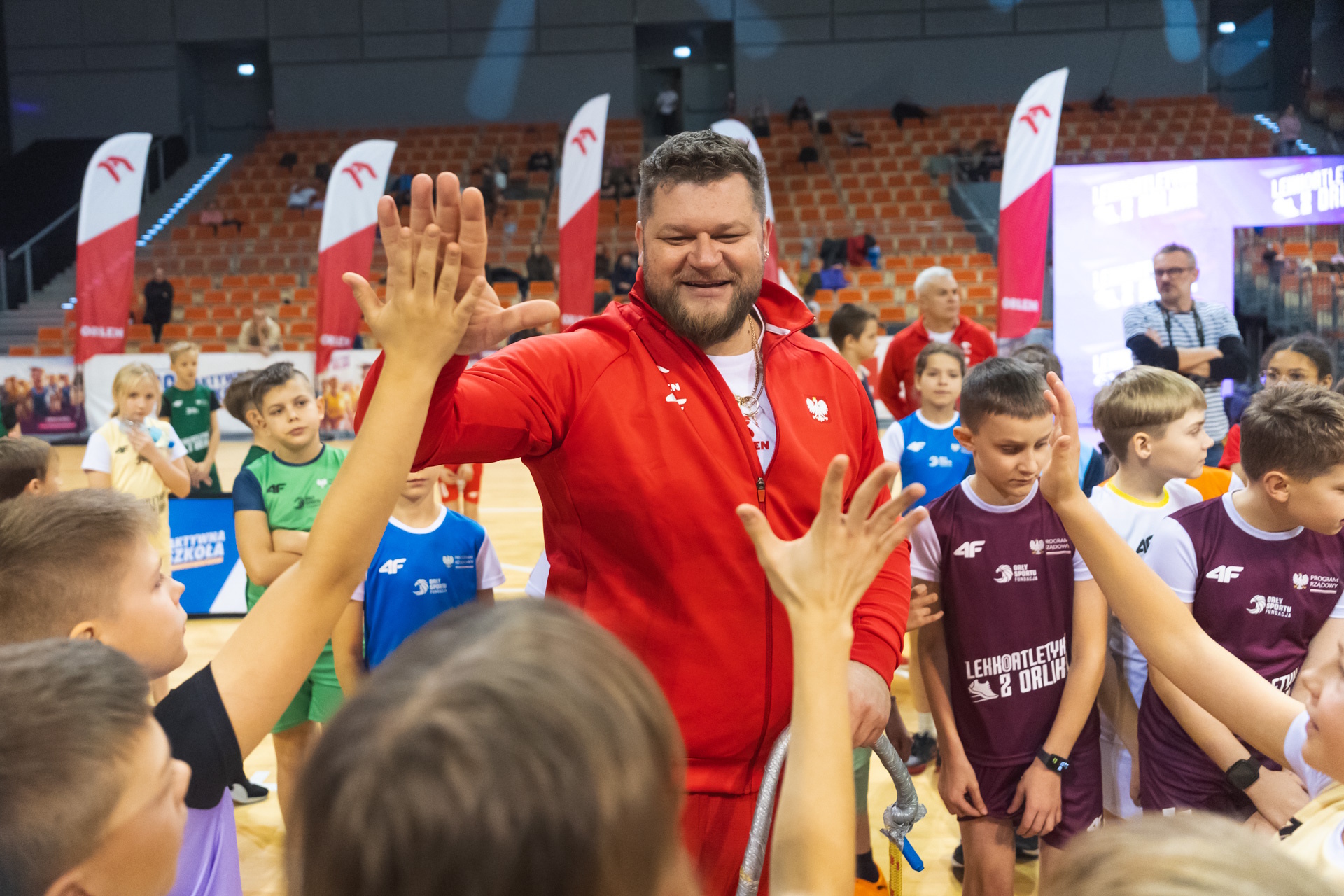 Paweł Fajdek przybijający piątki z dziećmi