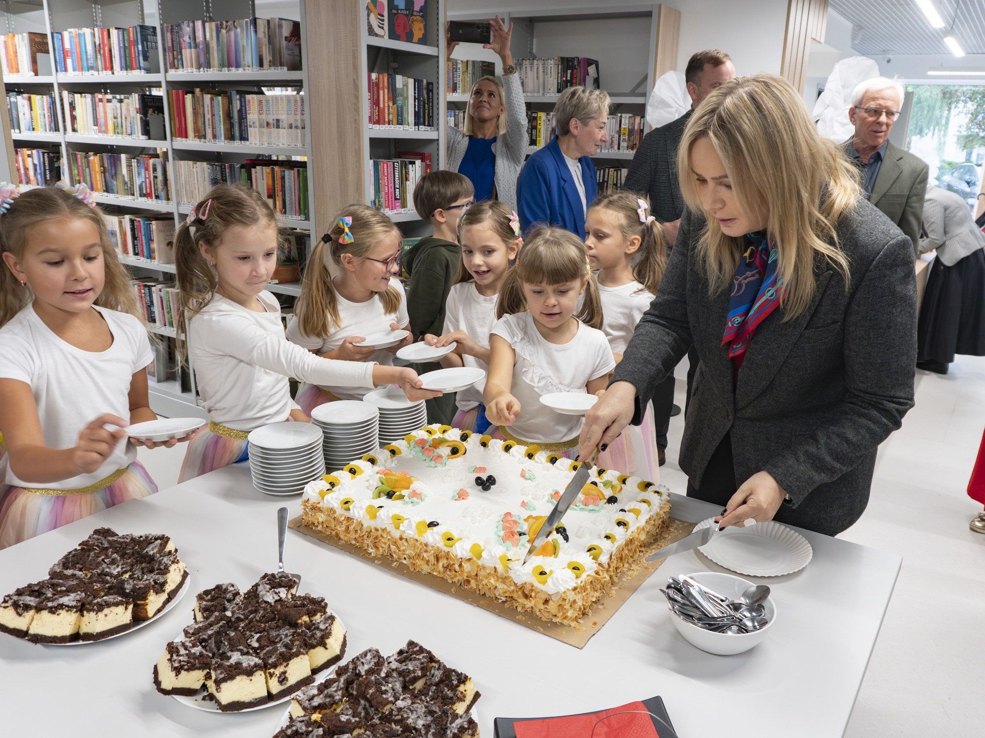 prezydent Gliwic kroi tort, wokół niej stoją małe dziewczynki