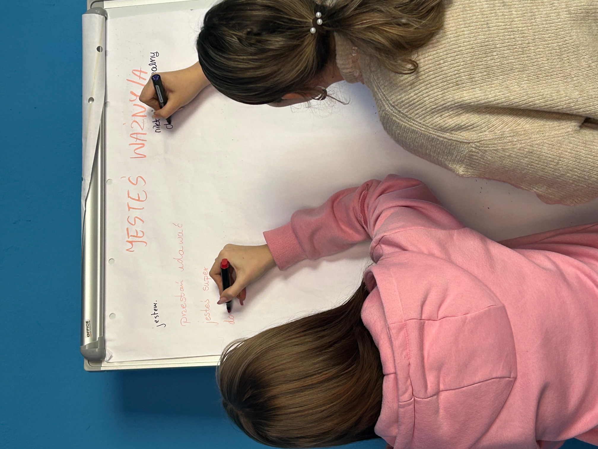 Dziewczyny piszące coś na tablicy