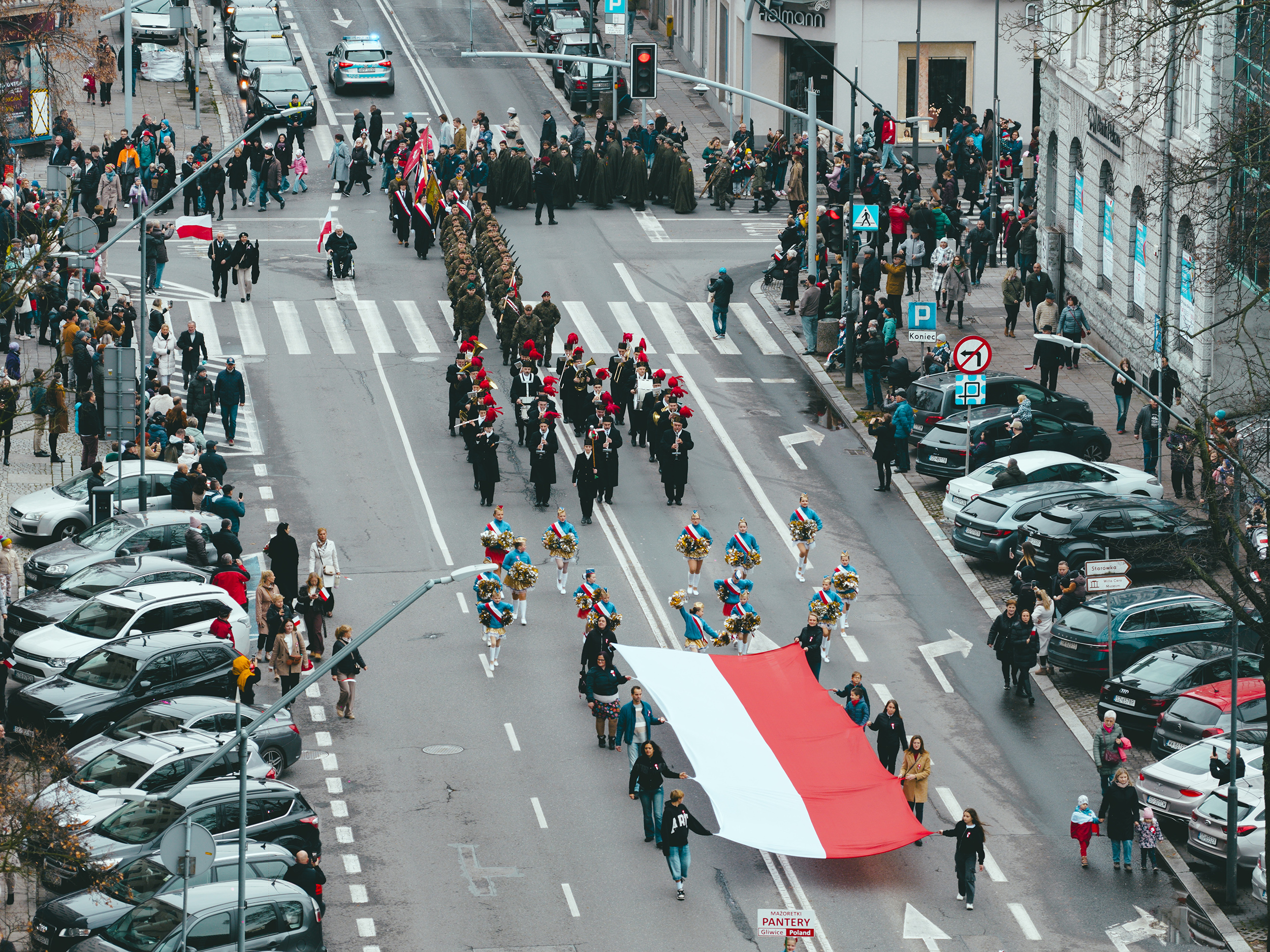 Przemarsz przez miasto z flagą Polski. Ujęcie z drona