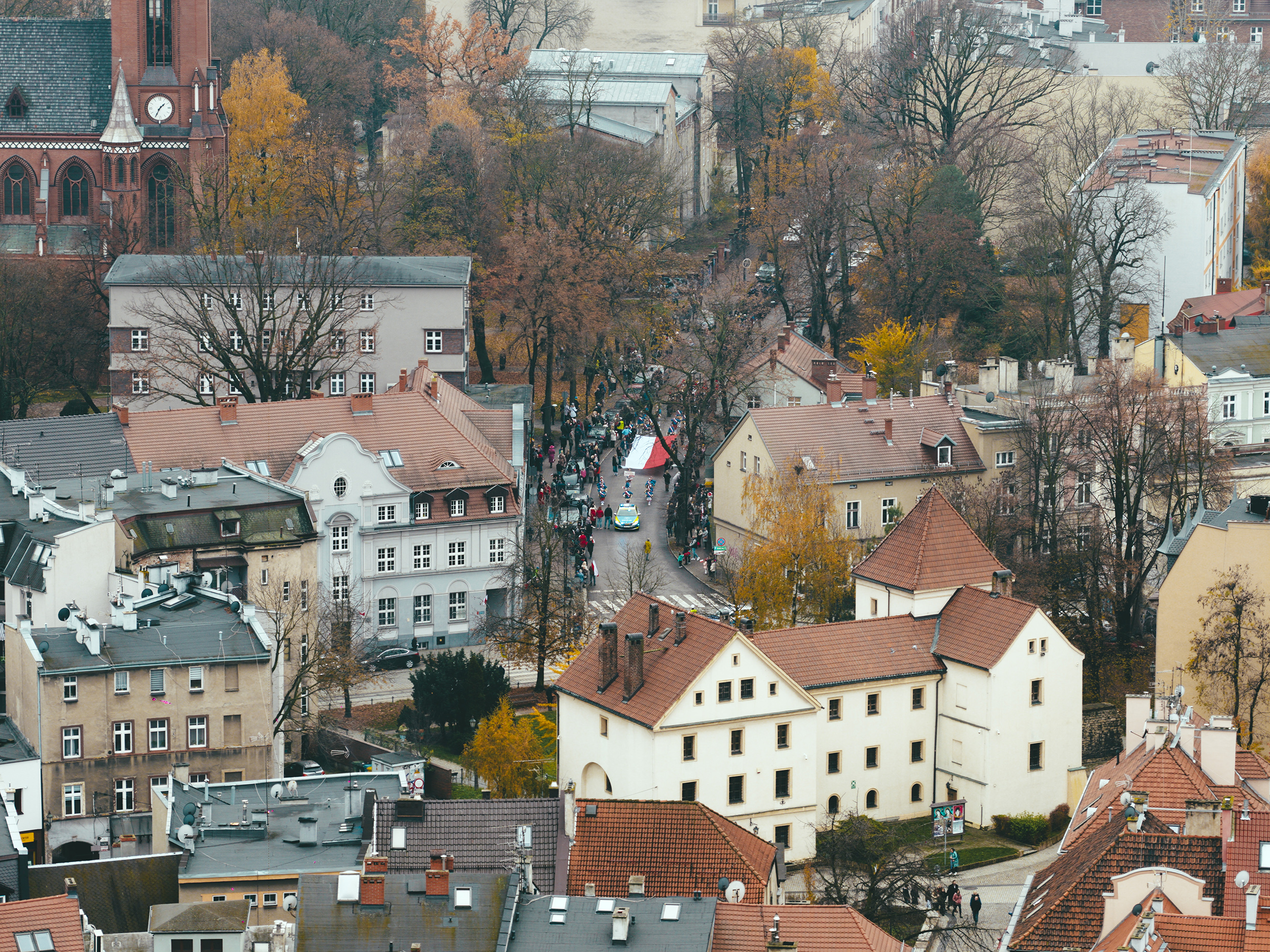 Przemarsz przez miasto z flagą Polski. Ujęcie z drona