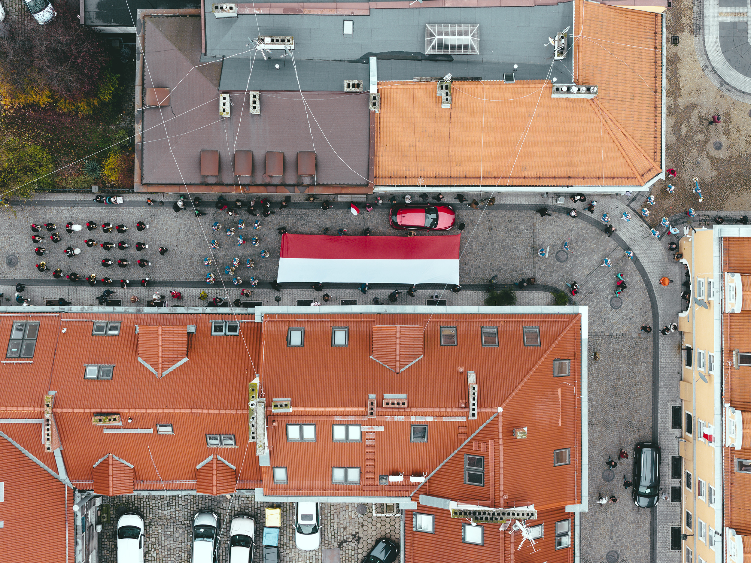 Przemarsz przez miasto z flagą Polski. Ujęcie z drona
