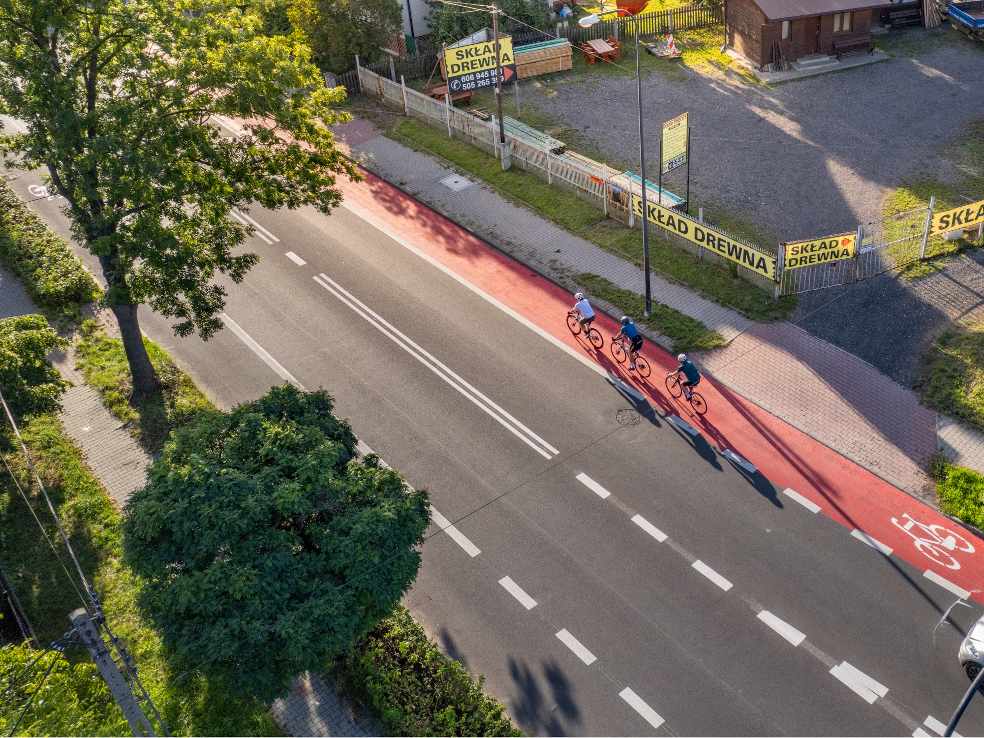 trzech rowerzystów widocznych z lotu ptaka jedzie pasem rowerowym ulicą Daszyńskiego