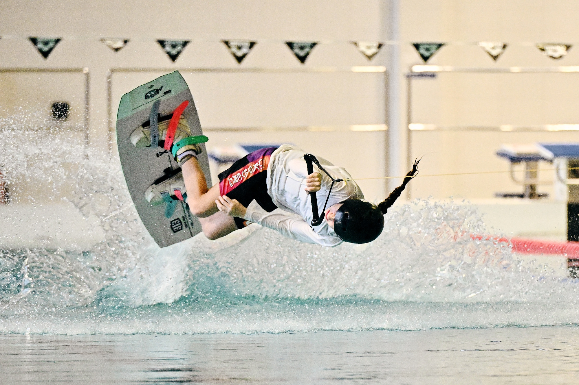 dziewczyna z warkoczem na desce, robi fikołka w wodzie