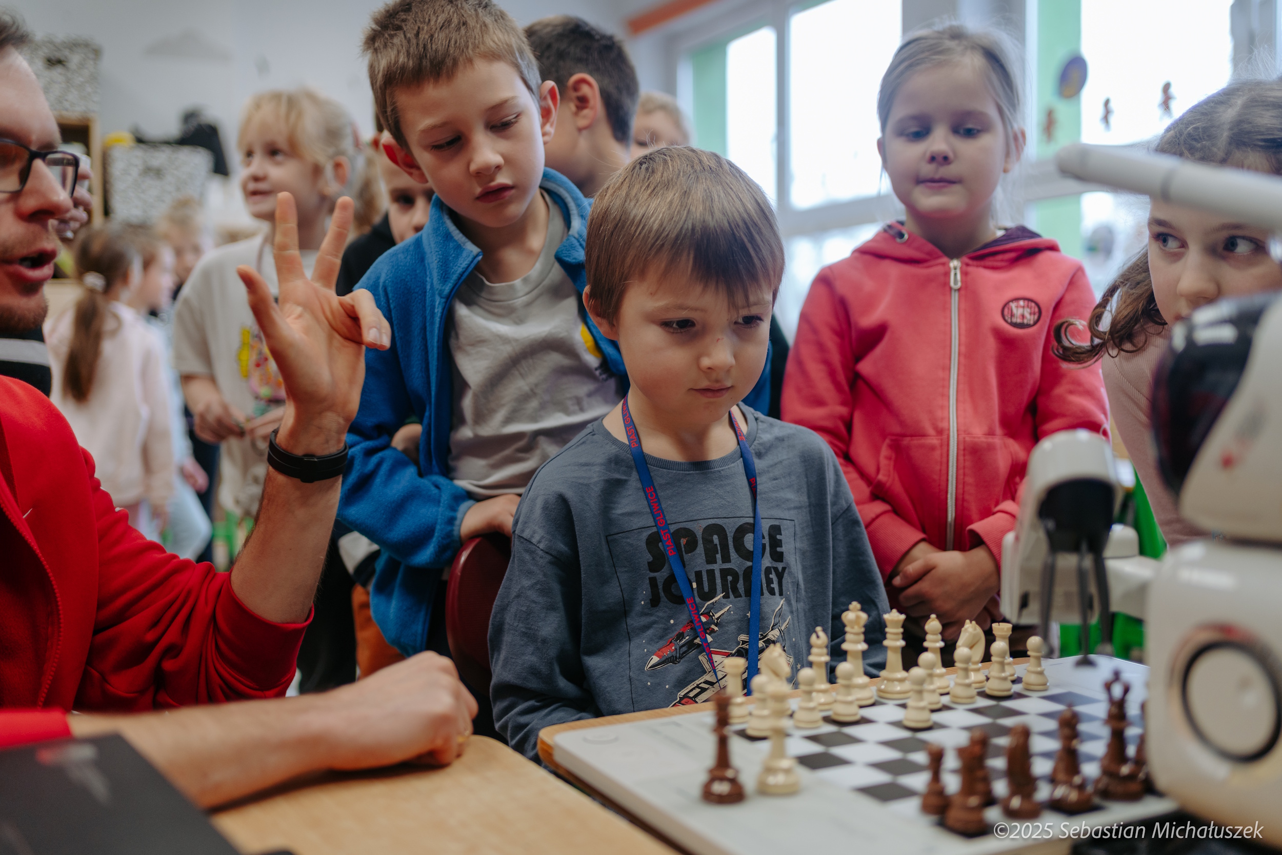 Dzieci grające w szachy z robotem