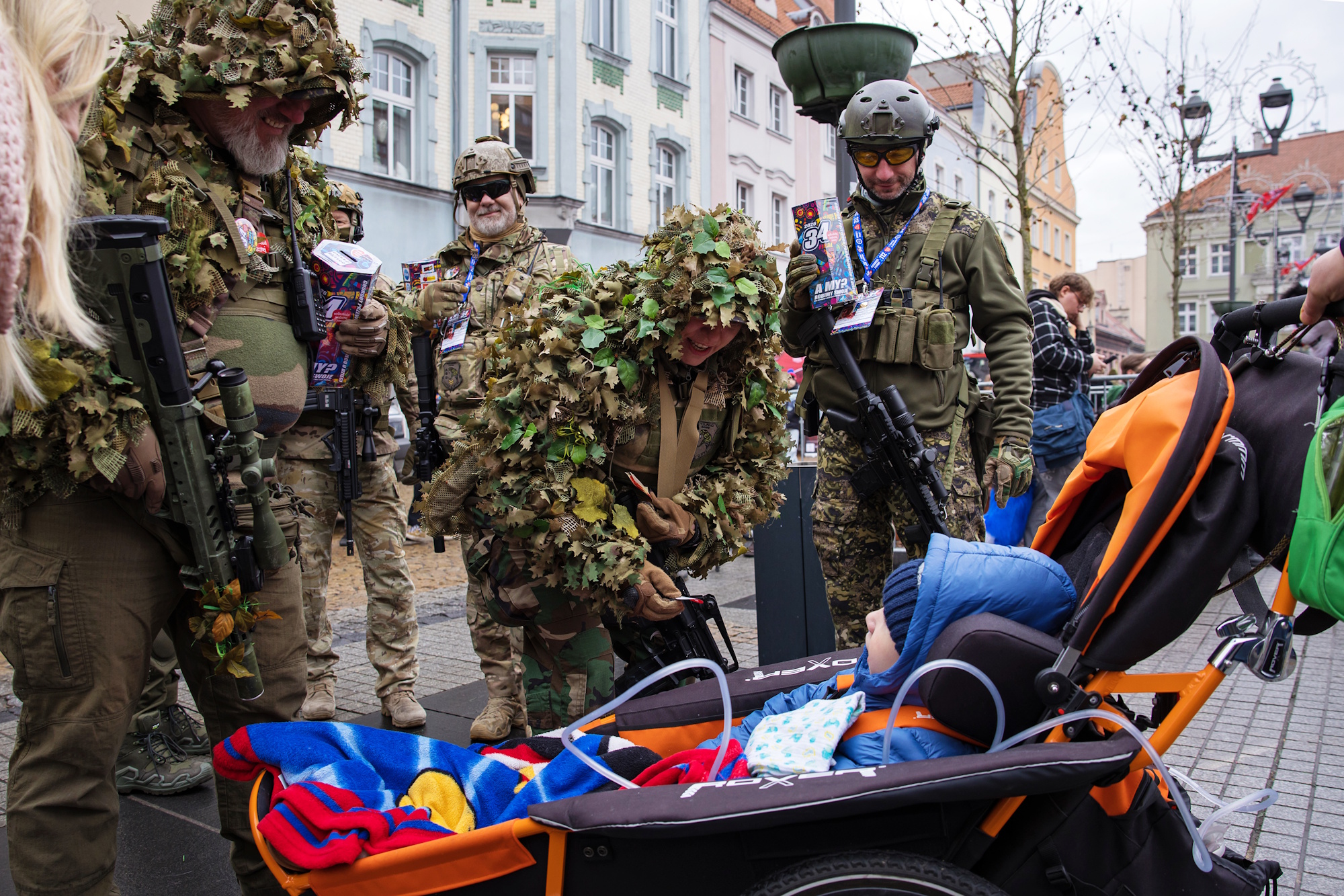 Żołnierze, przed nimi wózek z dzieckiem