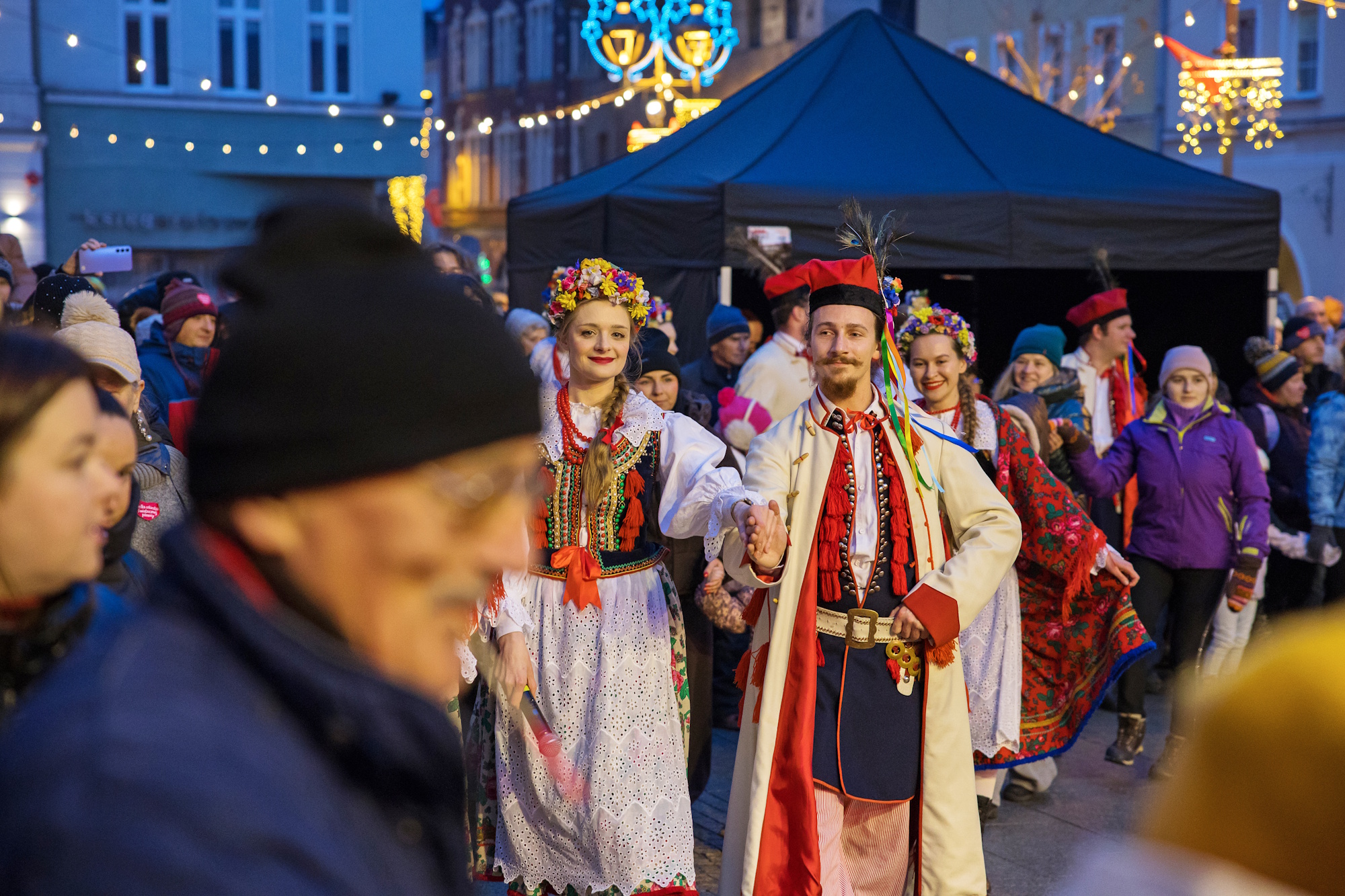 Ludzie w strojach ludowych tańczą poloneza