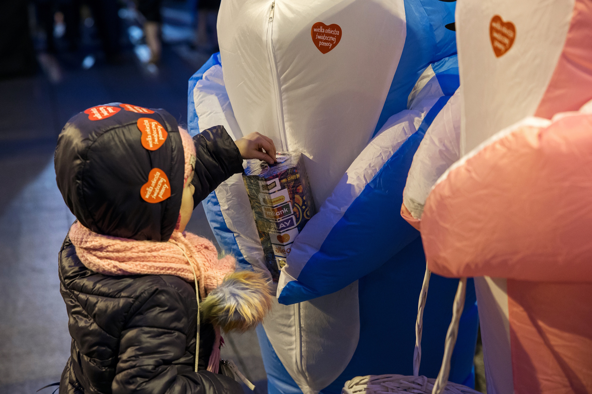 dziewczynka wrzuca pieniądze do puszki