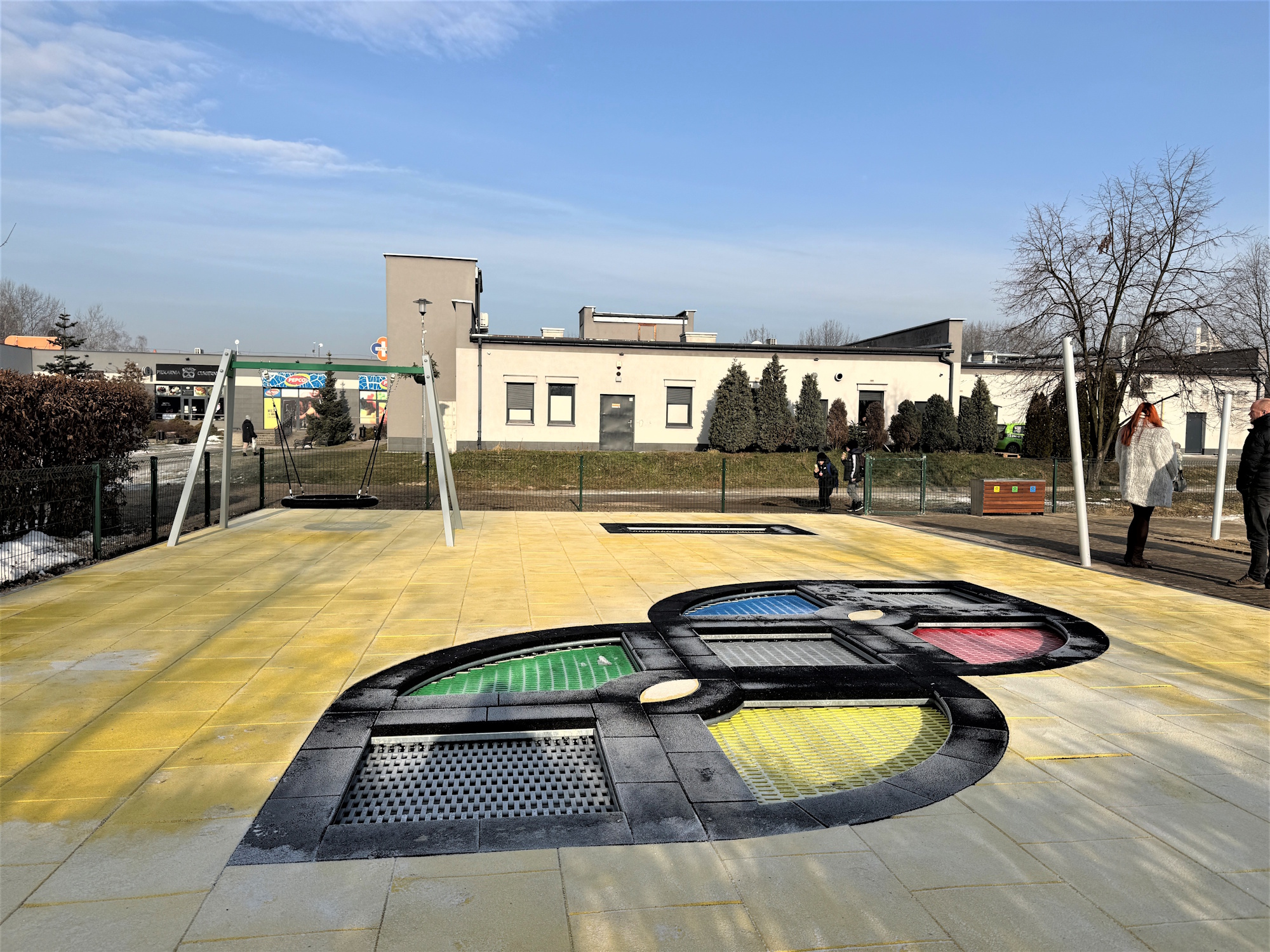 trampoliny i huśtawka na placu zabaw