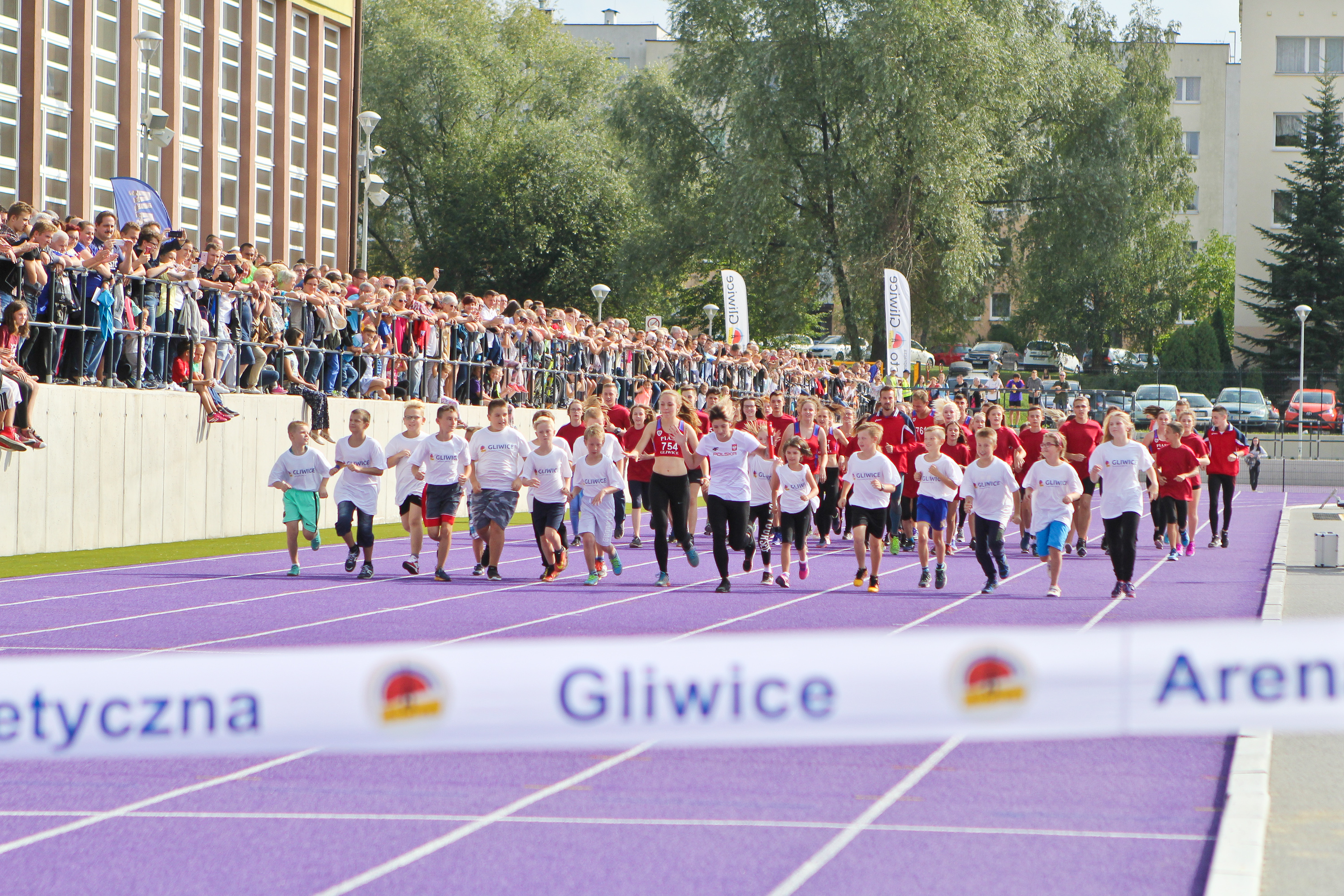 dzieci biegnące po arenie lekkoatletycznej
