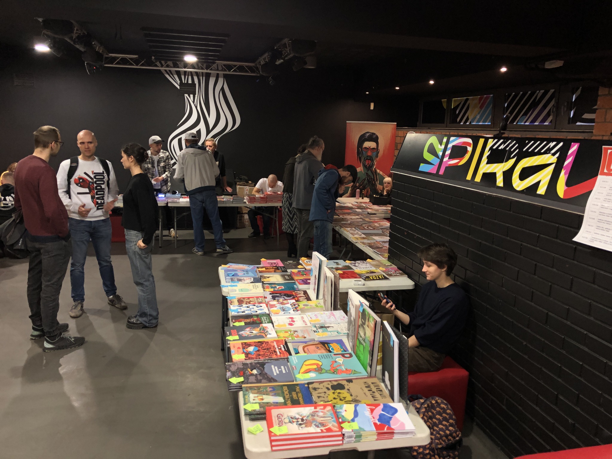 Ludzie przy stoiskach na imprezie komiksowej