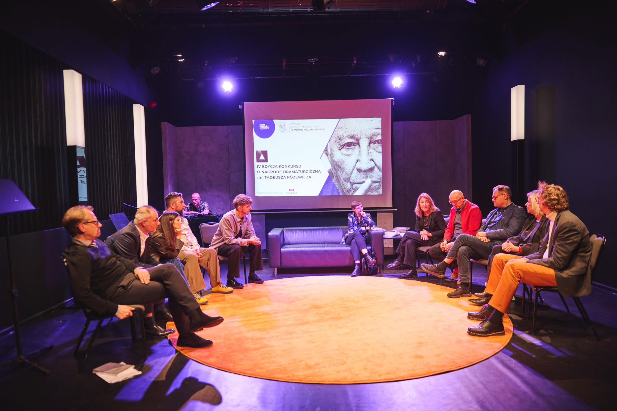 Ludzie siedzą na scenie i rozmawiają