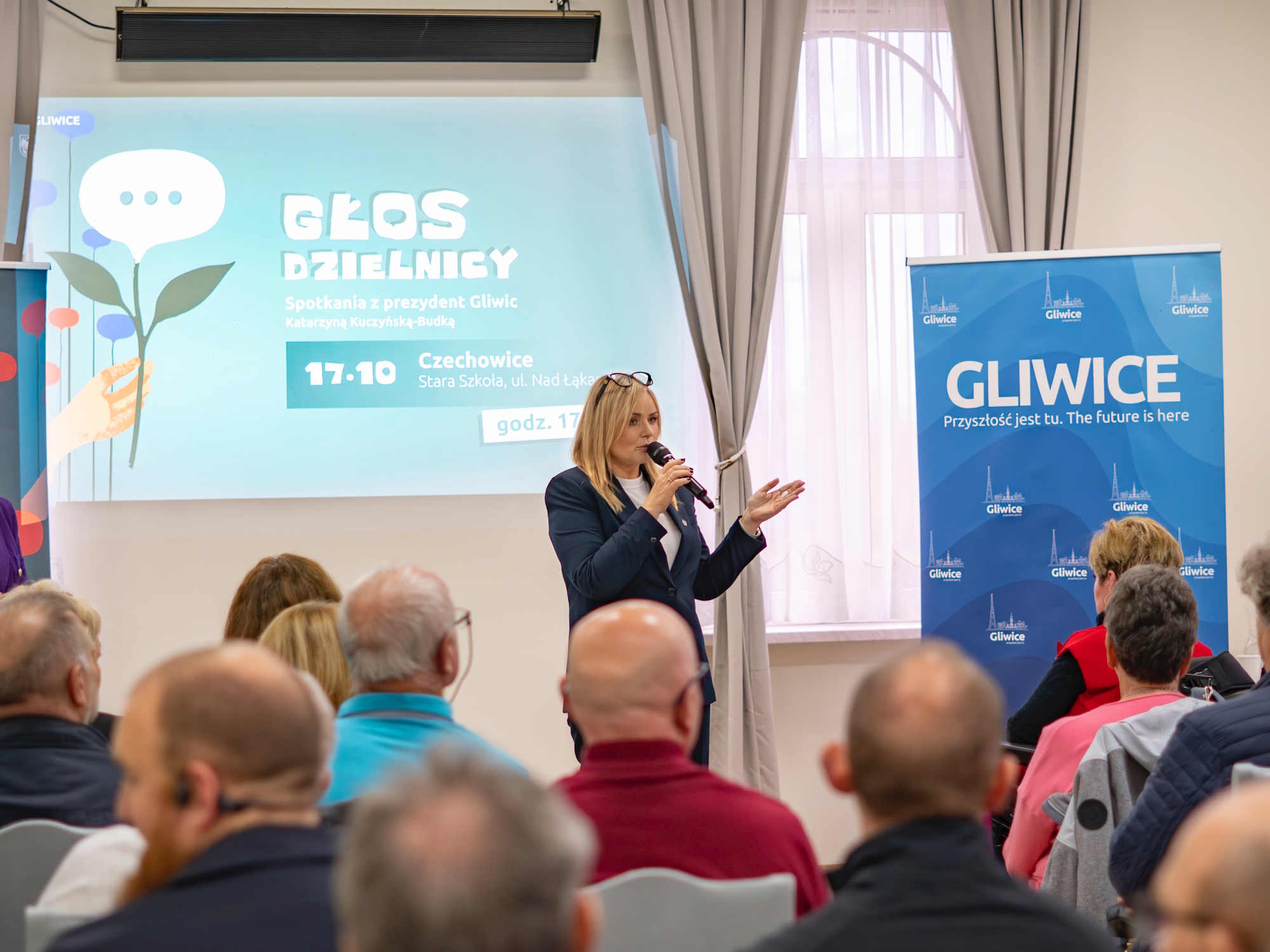 prezydent Gliwic mówi do mikrofonu, mieszkańcy słuchają