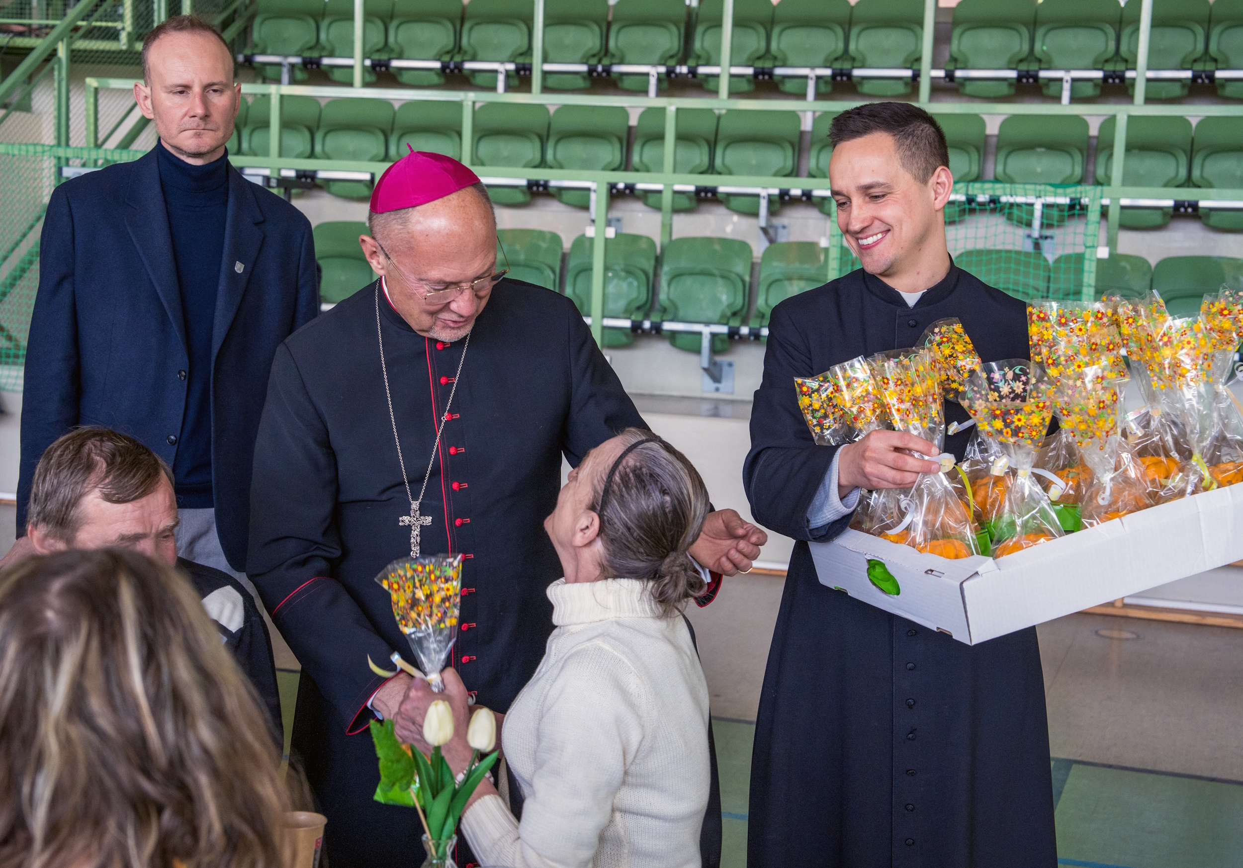 Biskup i jałmużnik wręczający babki wielkanocne