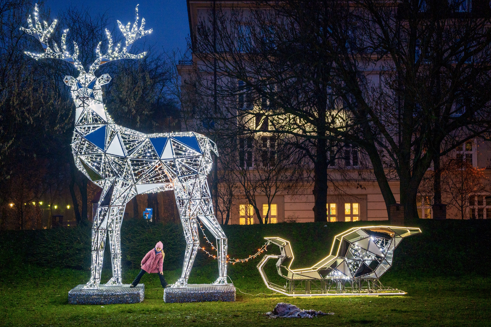 świecący renifer z saniami i dziewczynka