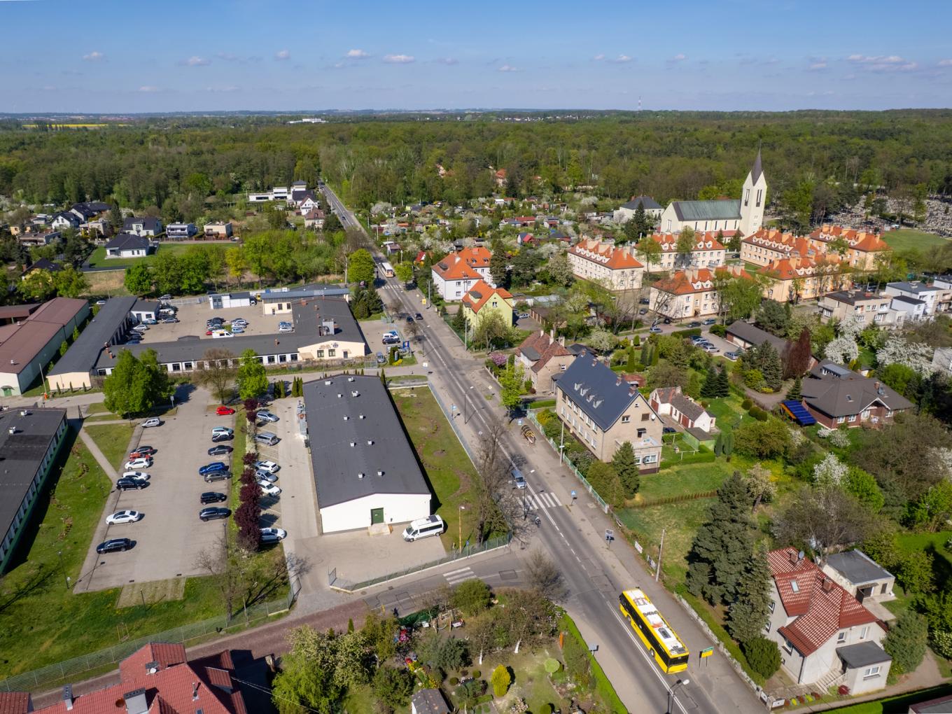 widok z lotu ptaka na ulicę Strzelców Bytomskich w Łabędach. Widoczne są budynki, kościół, zazielenienia