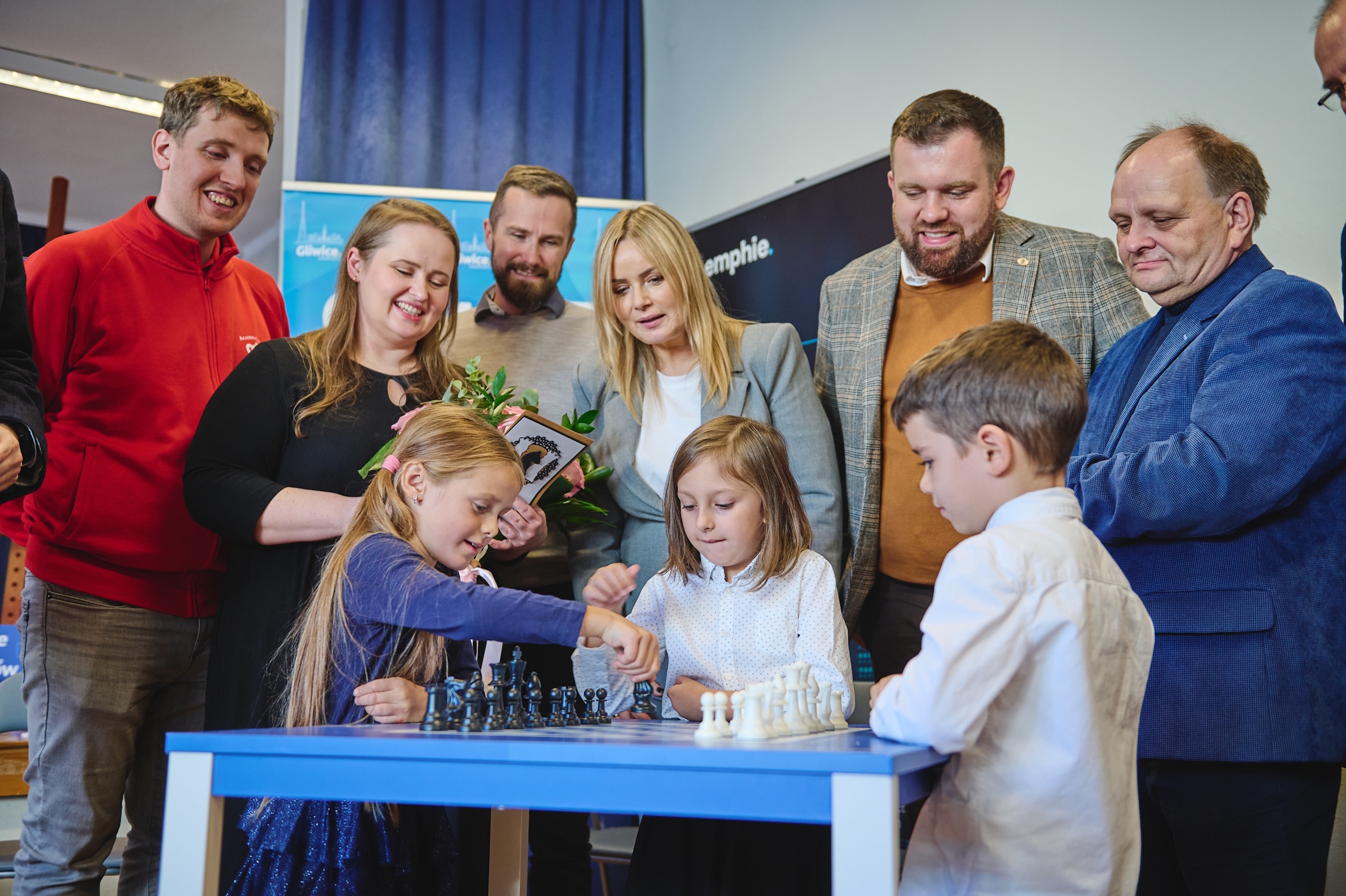 Dzieci grające w szachy przy organizatorach projektu