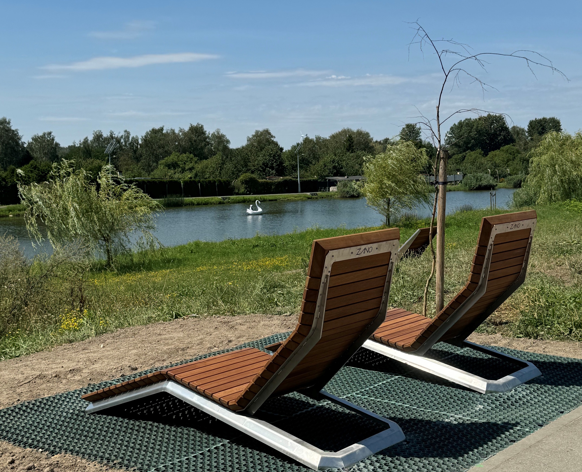 dwa leżaki przy stawie letnią porą