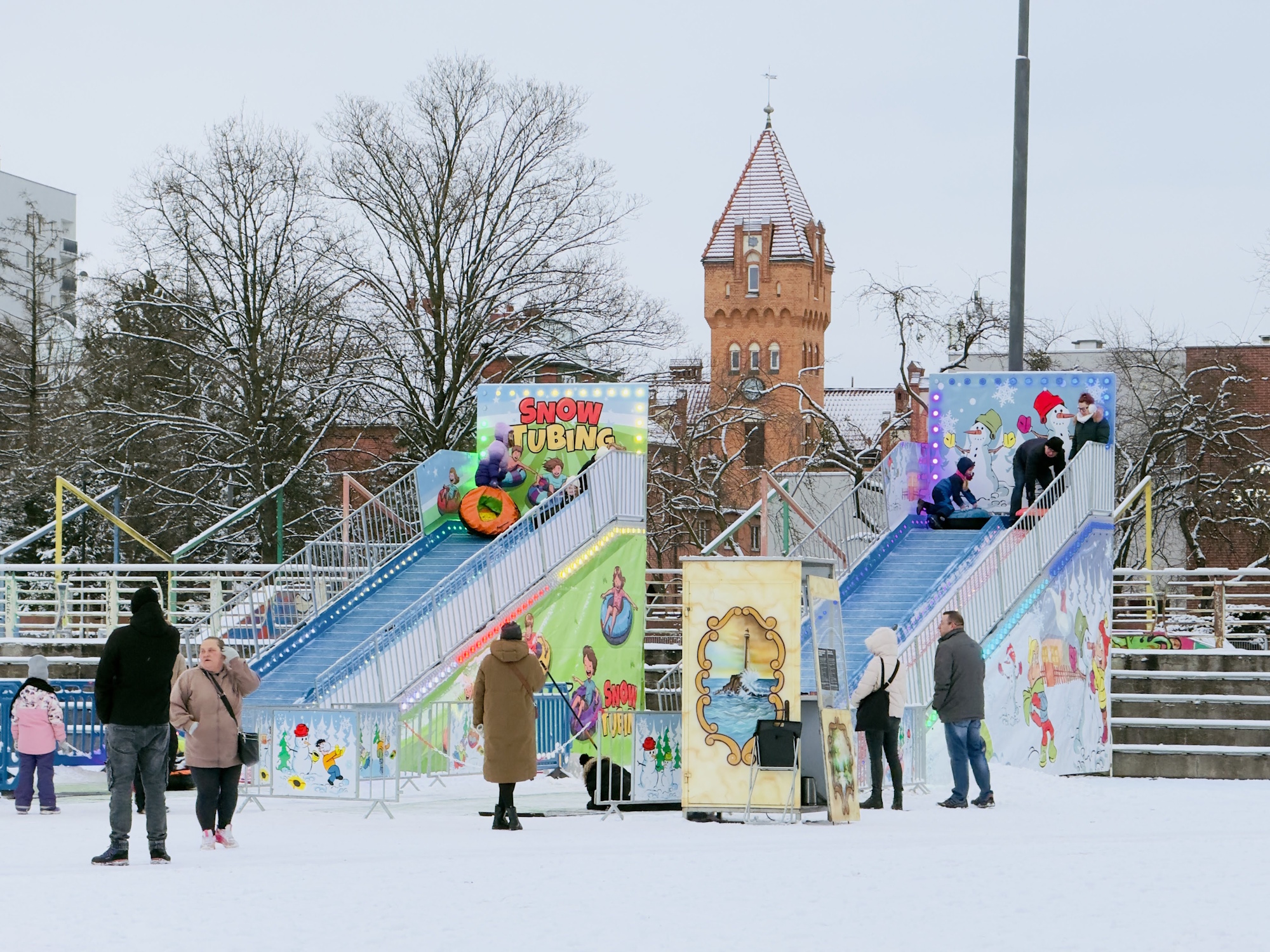 ślizgawka na Placu Krakowski, a na niej dzieci, wokół śnieg