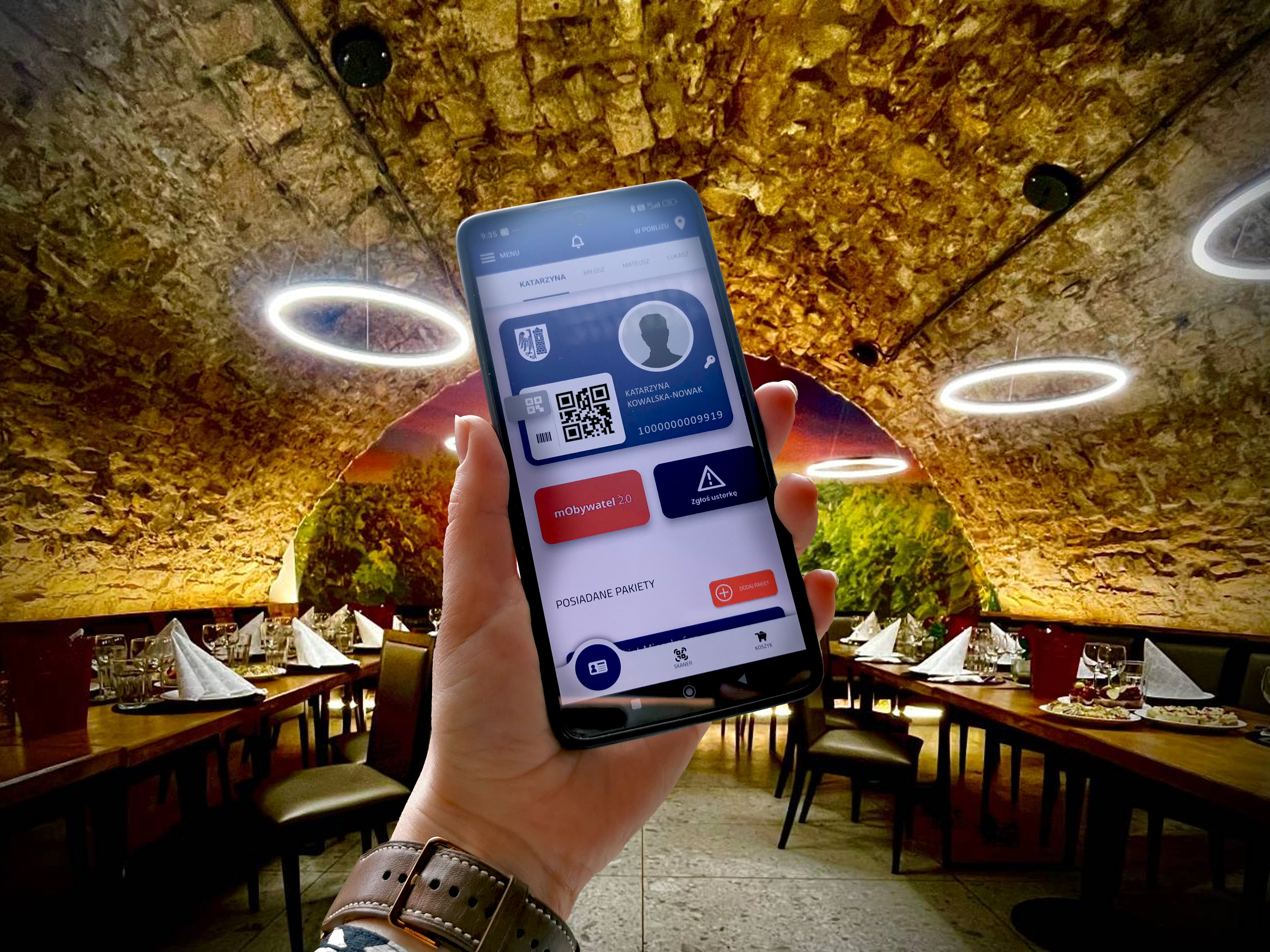 Dłoń z aplikacją GKM na tle restauracji