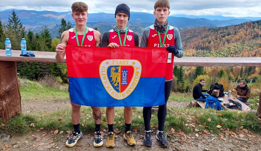 Lekkoatleci Piasta pozujący z flagą z herbem Gliwic