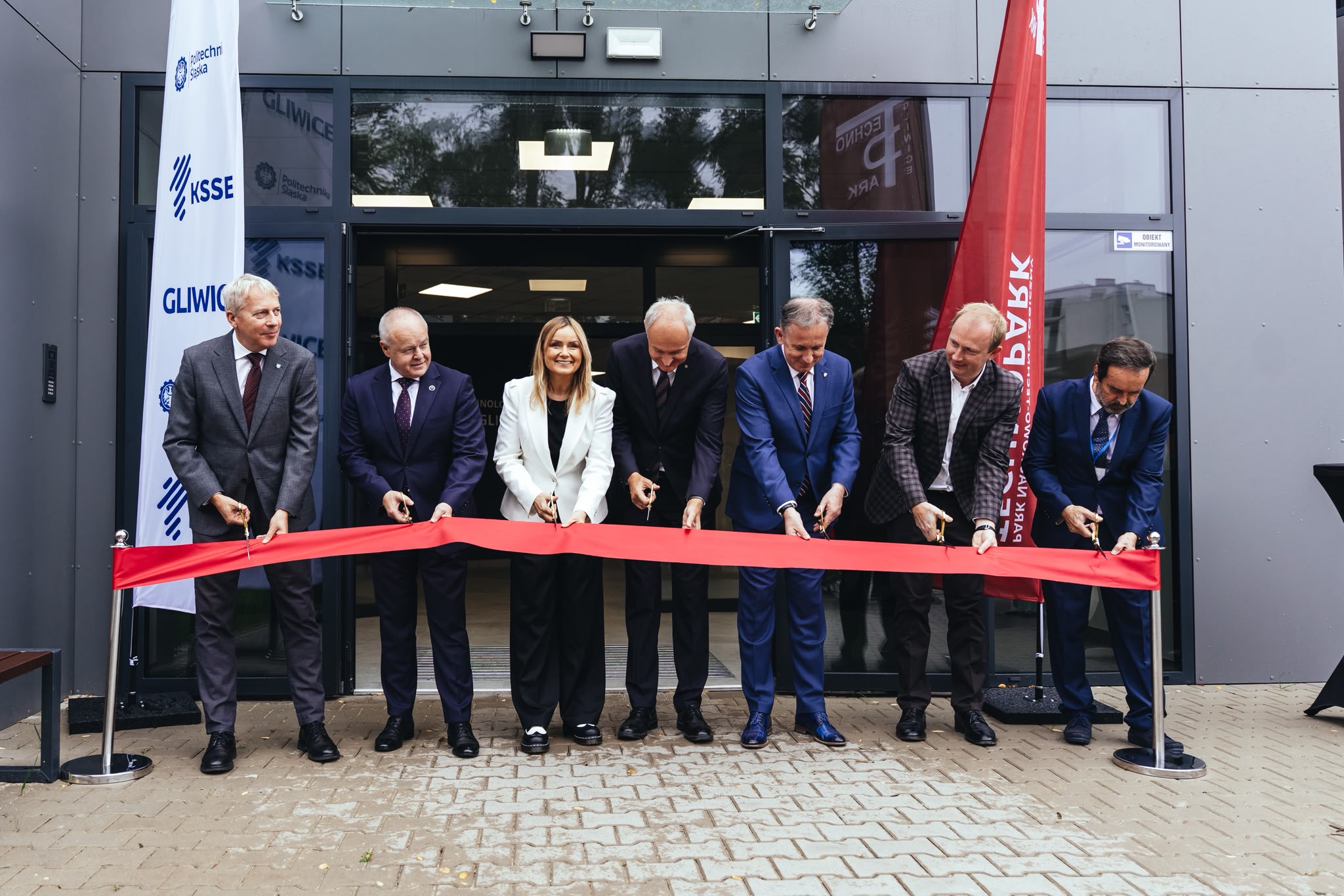 Grupa ludzi przecinających wstęgę