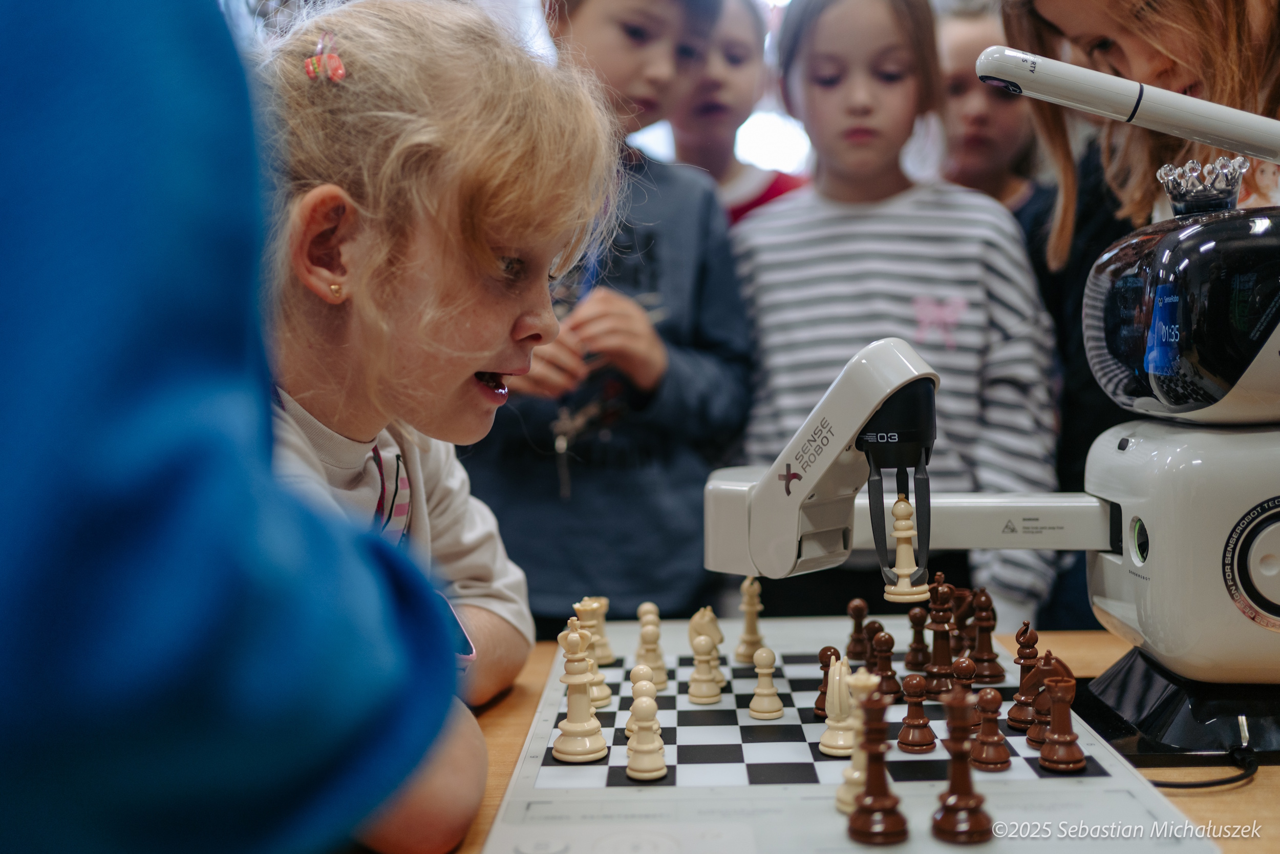 Dzieci grające w szachy z robotem