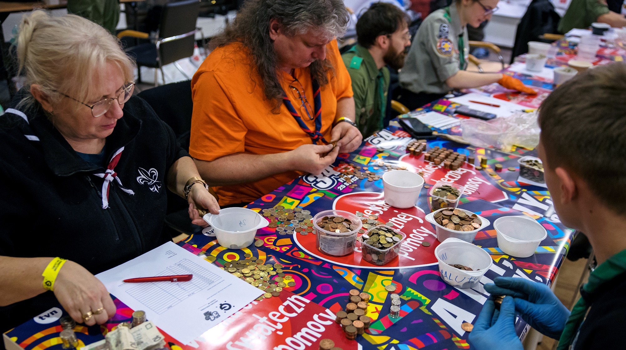 ludzie siedzący przy stole i liczący pieniądze