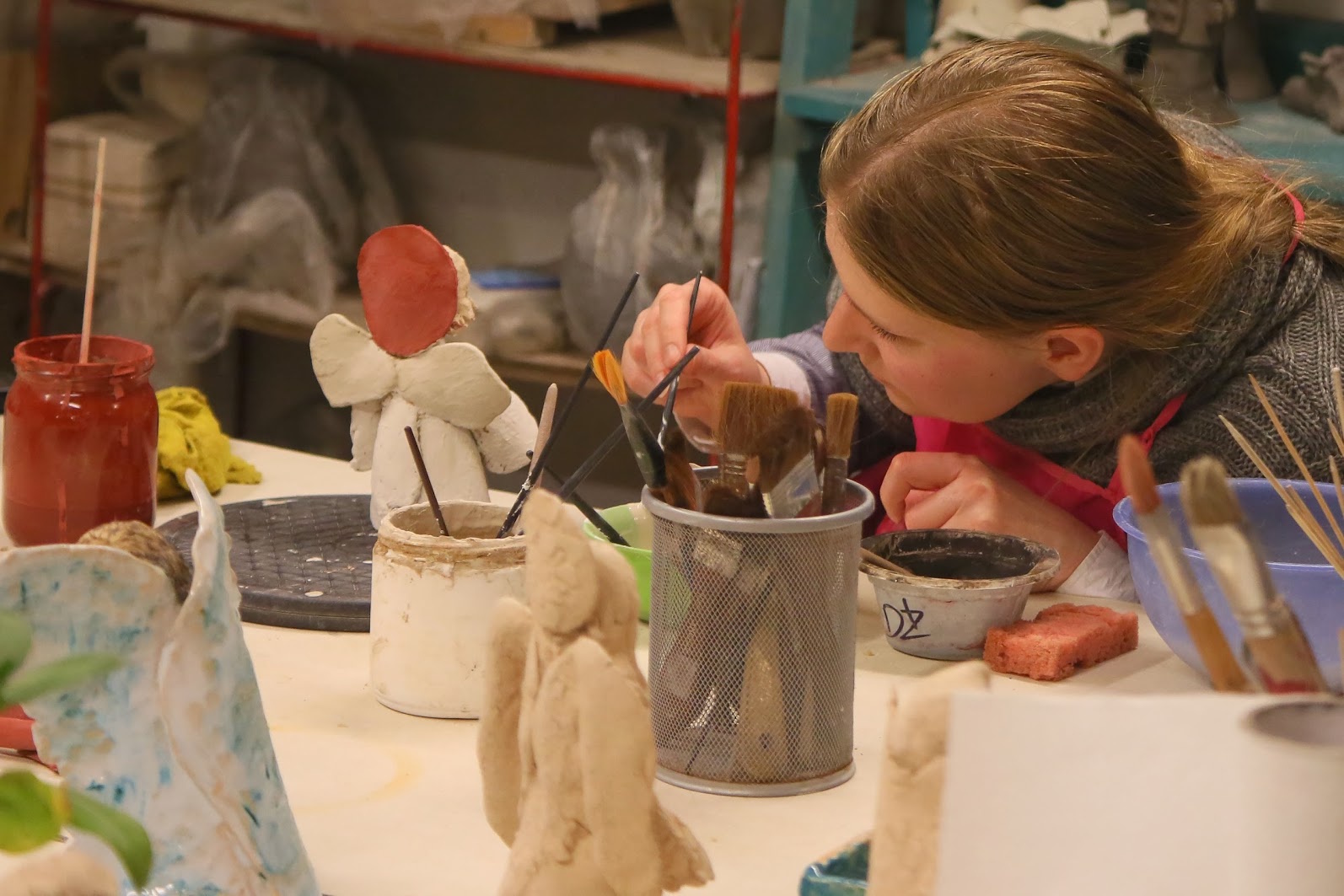 dziewczynka z pędzlem maluje przy stole